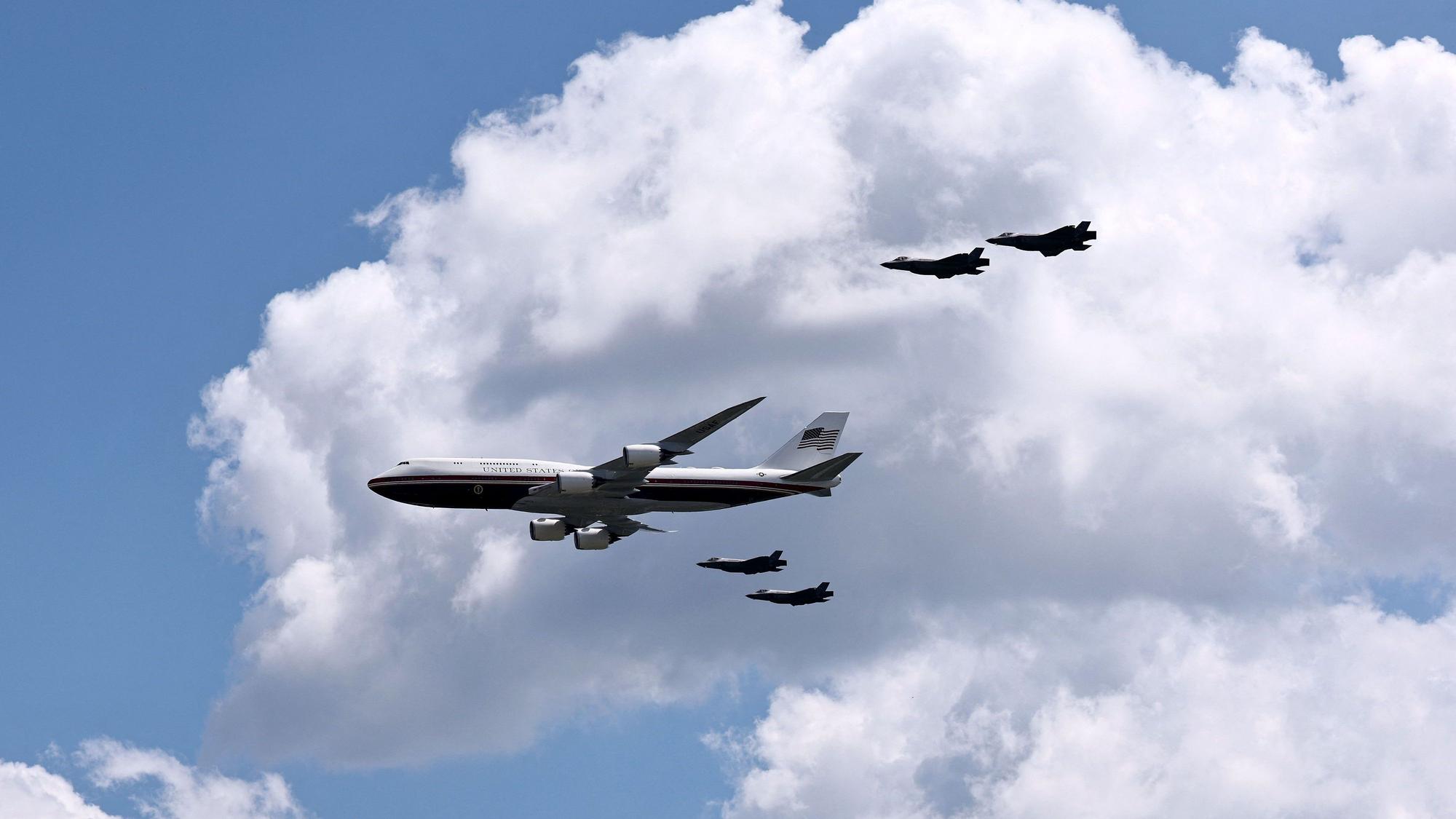 Die Air Force One mit vier Kampfjets bei einem Flyover.