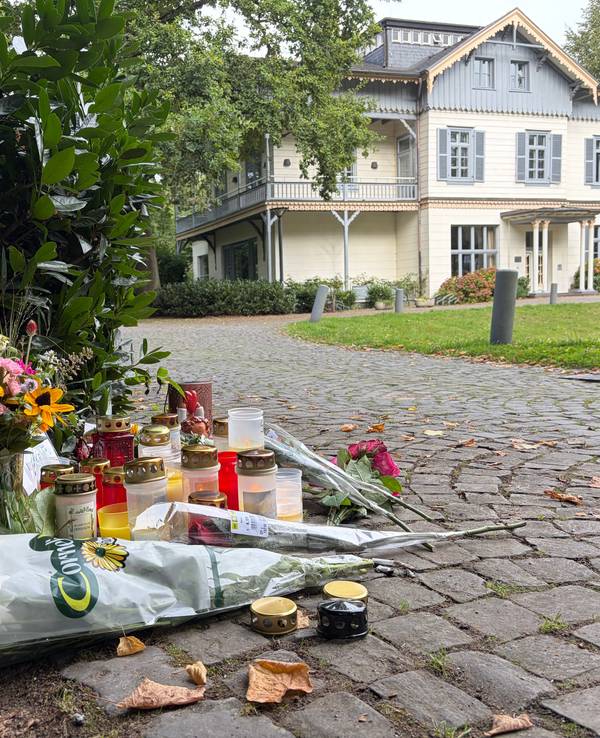 An einem Tatort liegen Blumensträuße, stehen Kerzen.