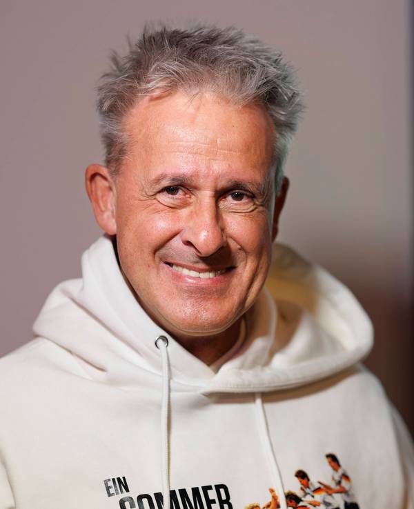 Pierre Littbarski lächelt in die Kamera.