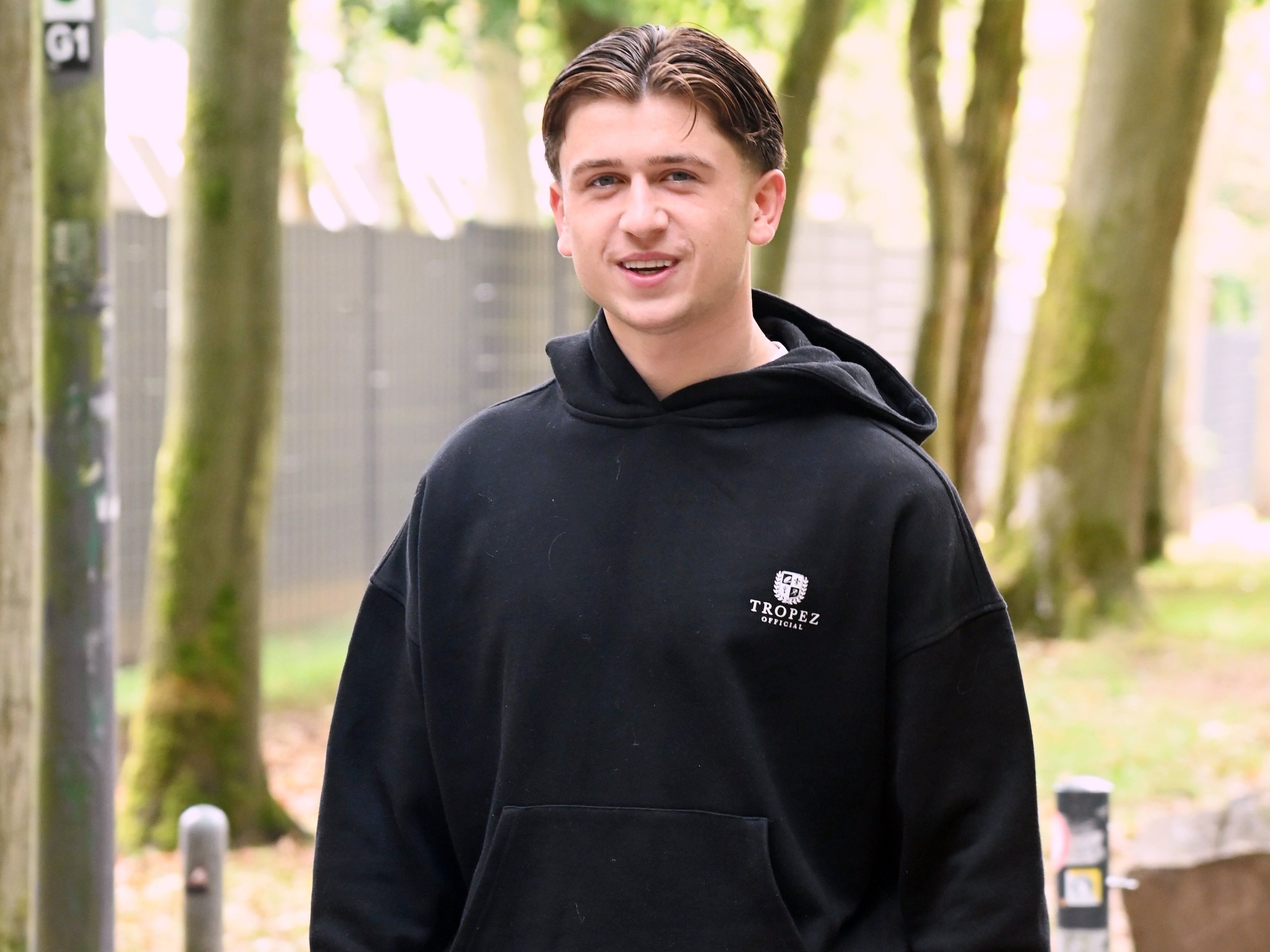 Mikey Moore lächelt in einem schwarzen Hoodie in die Kamera.