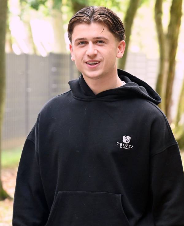 Mikey Moore lächelt in einem schwarzen Hoodie in die Kamera.