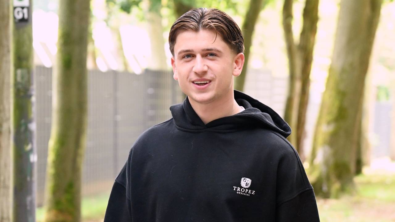 Mikey Moore lächelt in einem schwarzen Hoodie in die Kamera.
