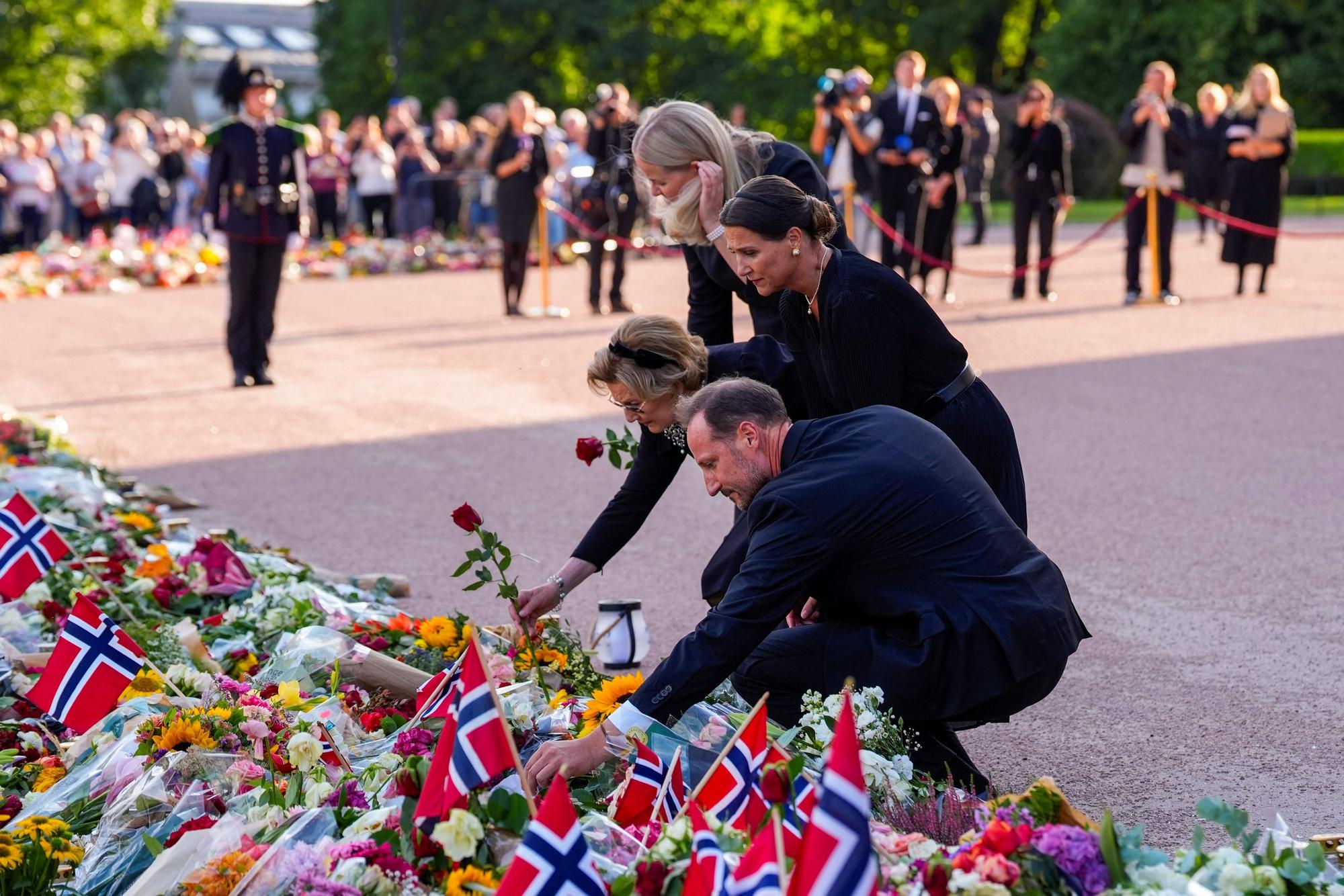 König Haakon VIII., Prinzessin Märtha Louise, Königin Sonja und Königin Mette-Marit betrachten die zahlreichen Blumen und Beileidsbekundungen der Trauernden auf dem Schlossplatz in Oslo.