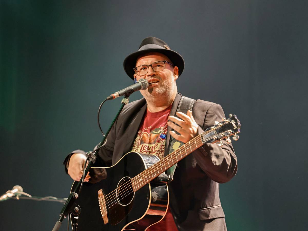 Björn Heuser steht mit Gitarre auf der Bühne.
