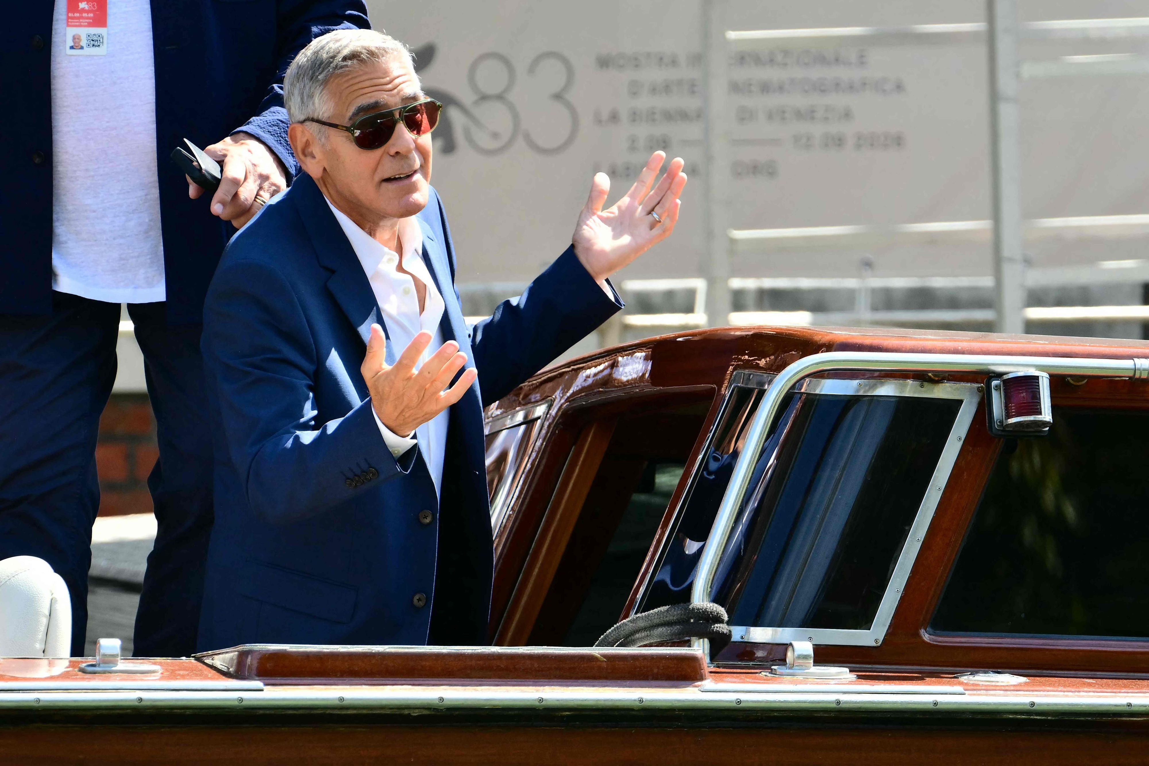 George Clooney gestikuliert auf einem Boot.