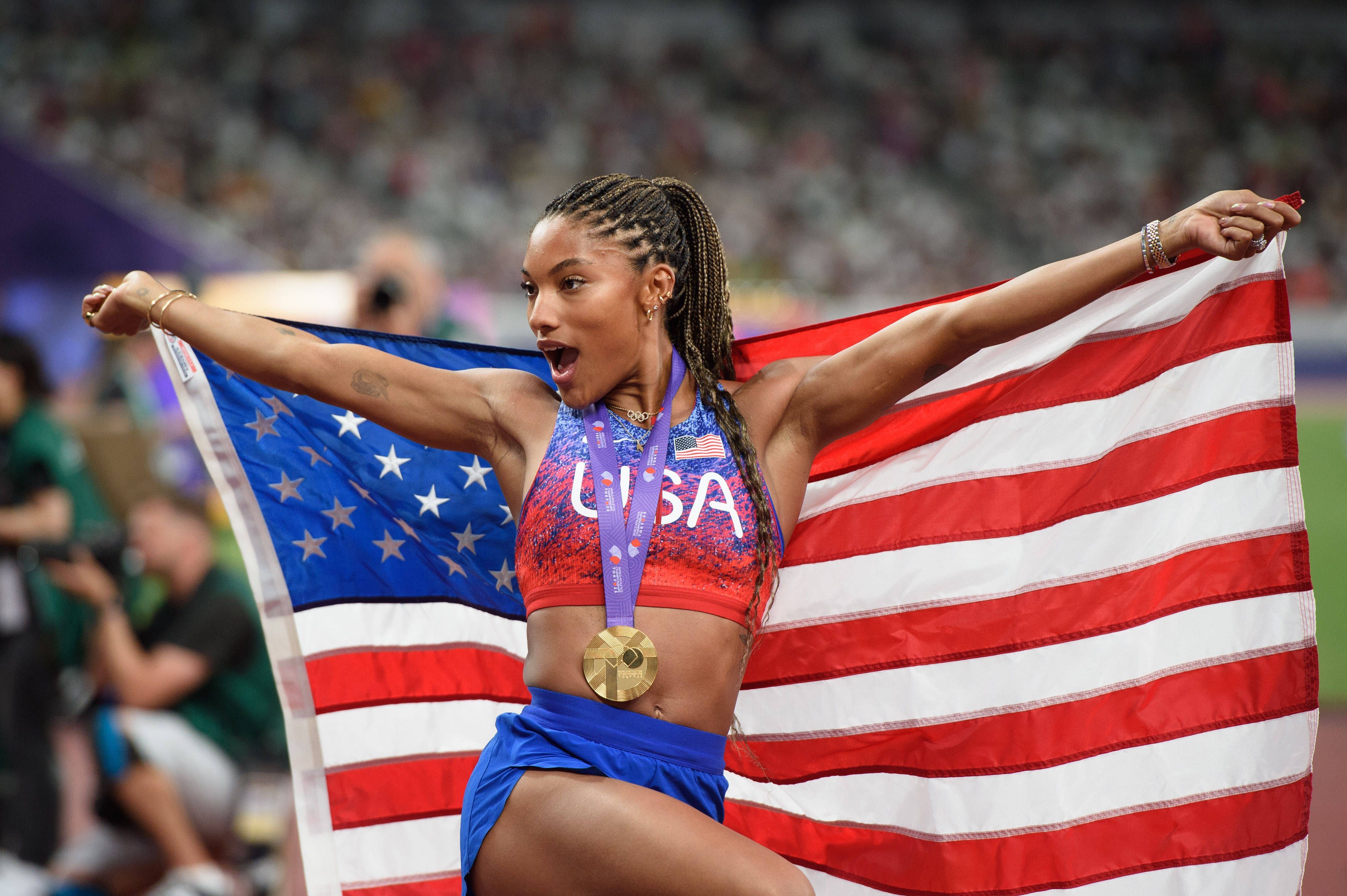 Tara Davis-Woodhall jubelt mit Goldmedaille und US-Flagge.