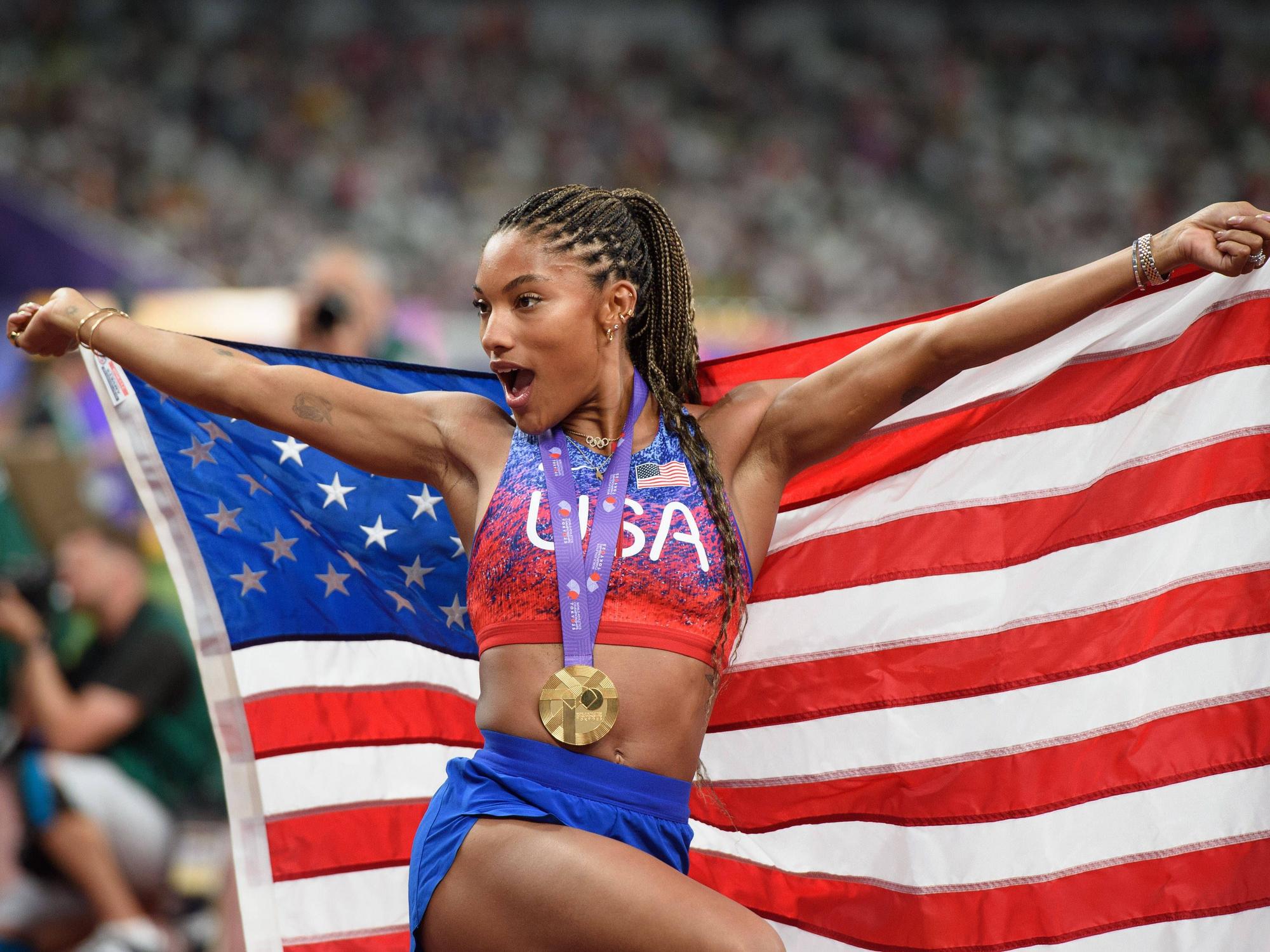 Tara Davis-Woodhall jubelt mit Goldmedaille und US-Flagge.