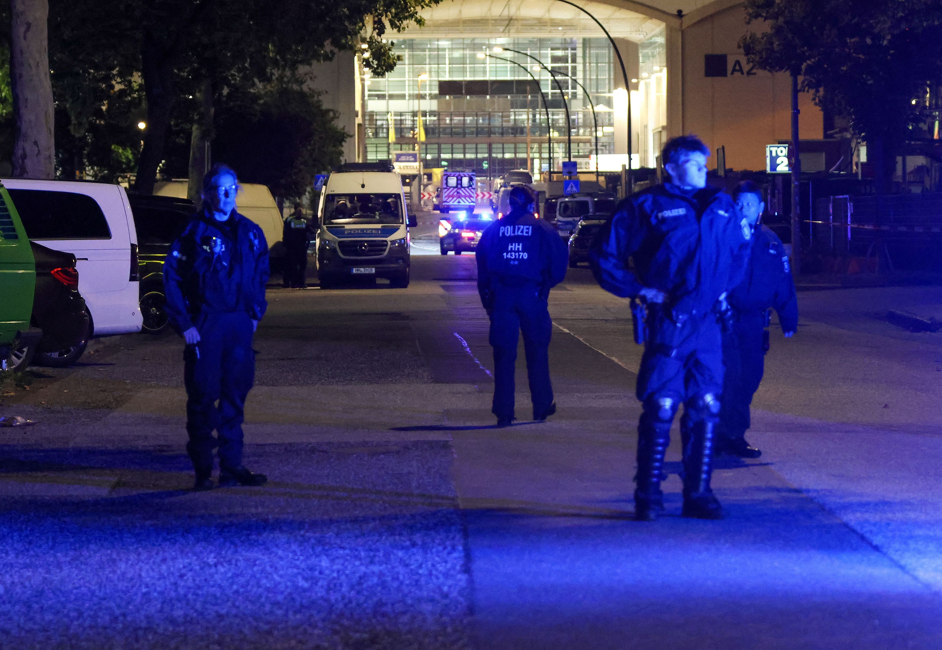 Mehrere Polizeikräfte stehen auf der Straße.