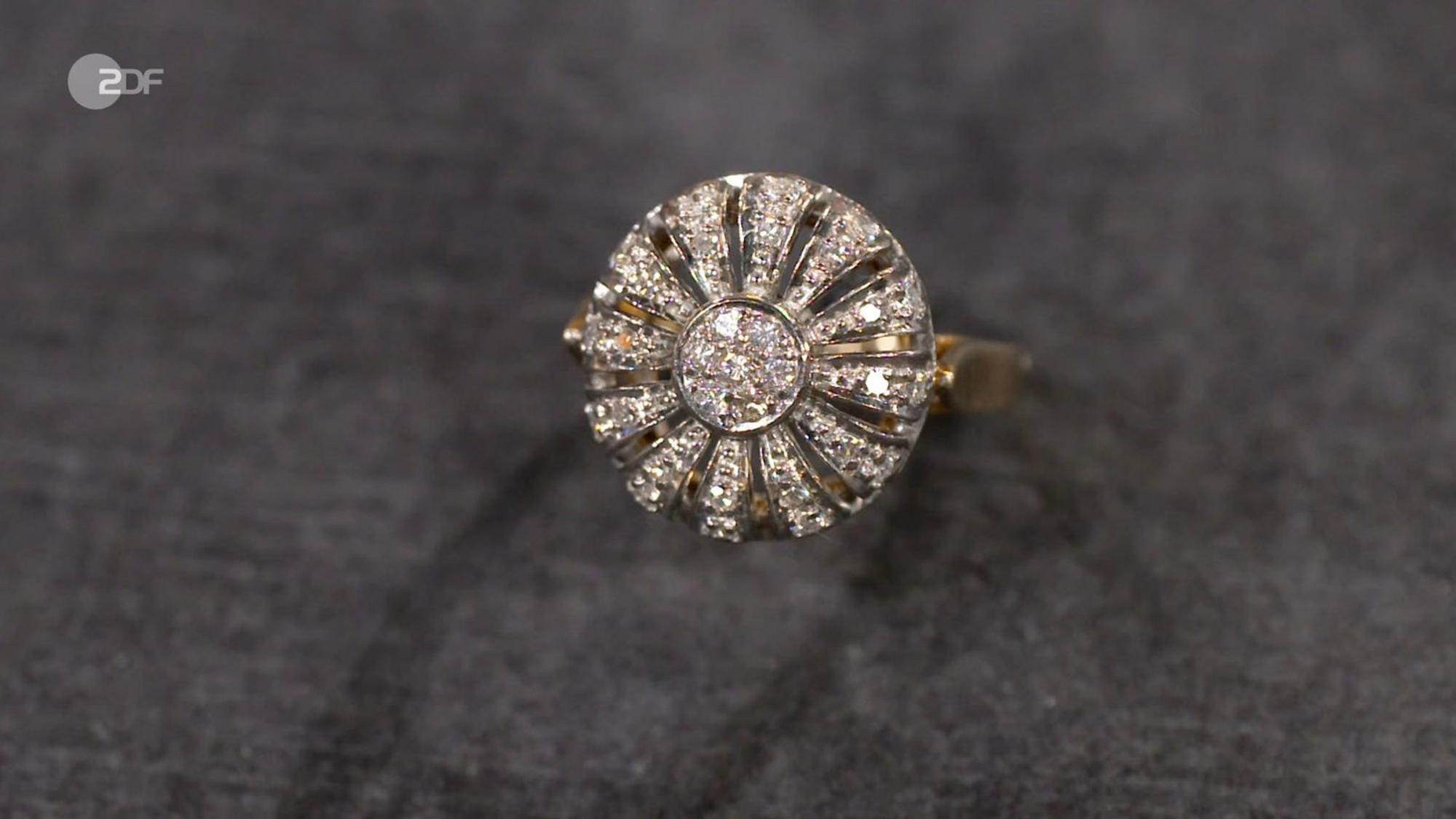 „Glitzer, Glitzer, Glitzer“, beschrieb Lichter den strahlenden Cocktail-Ring, den Heide Rezepa-Zabel als Schmuck aus den 1960er-Jahren an Op-Art erinnerte. Der Wunschpreis für den Ring aus 585er Gelbgold und Diamanten (Carat 0,36) lag bei 700 Euro. Die Expertin taxierte 1.000 bis 1.200 Euro. Anaisio Guedes zahlte sogar 1.350 Euro.
(Bild: ZDF)