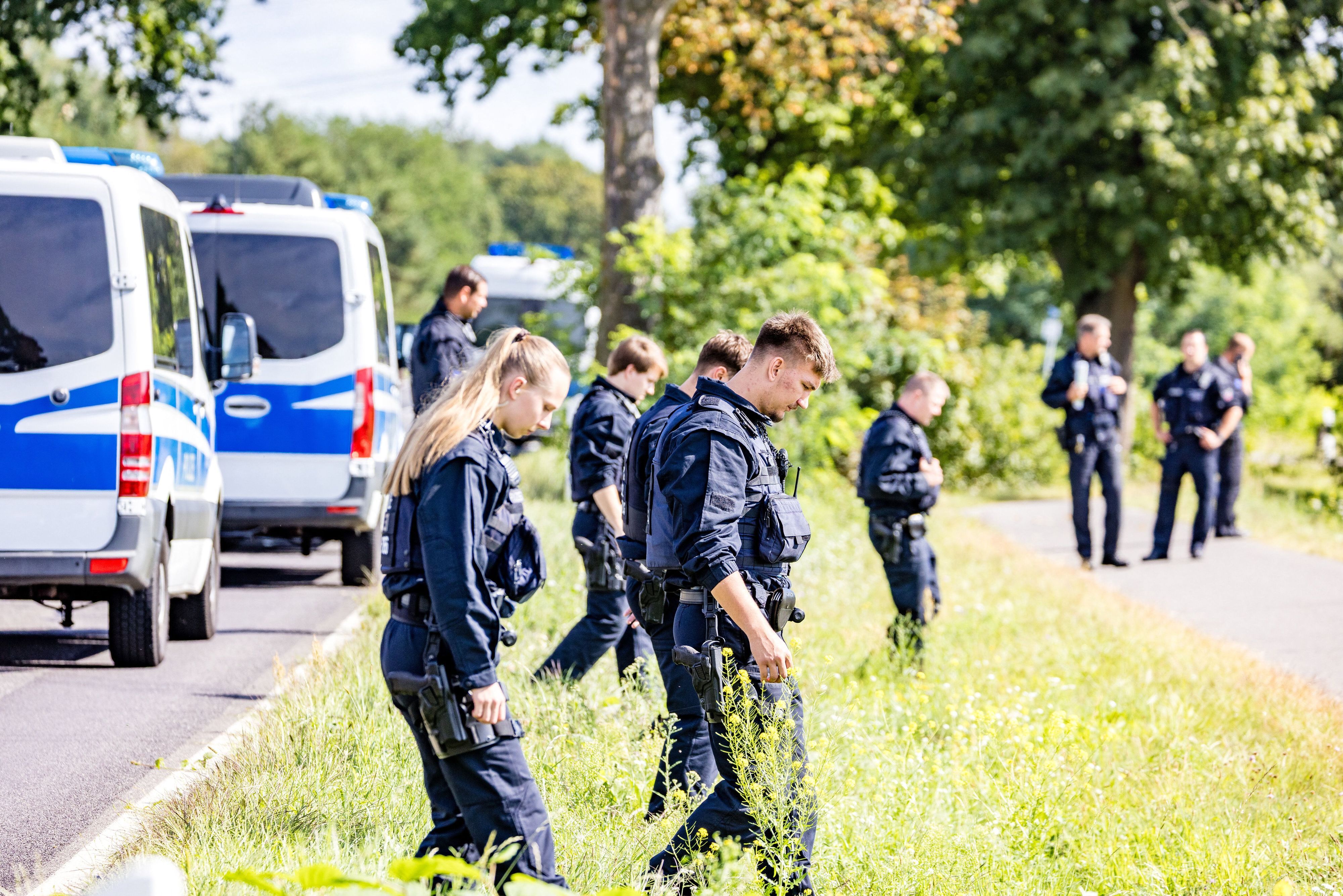 Einsatzkräfte einer Polizeihundertschaft durchsuchen großräumig die Umgebung. Nach der Sabotage am Stromnetz in Südbrandenburg sucht die Polizei vor Ort weiter nach Spuren, um die Täter zu ermitteln.