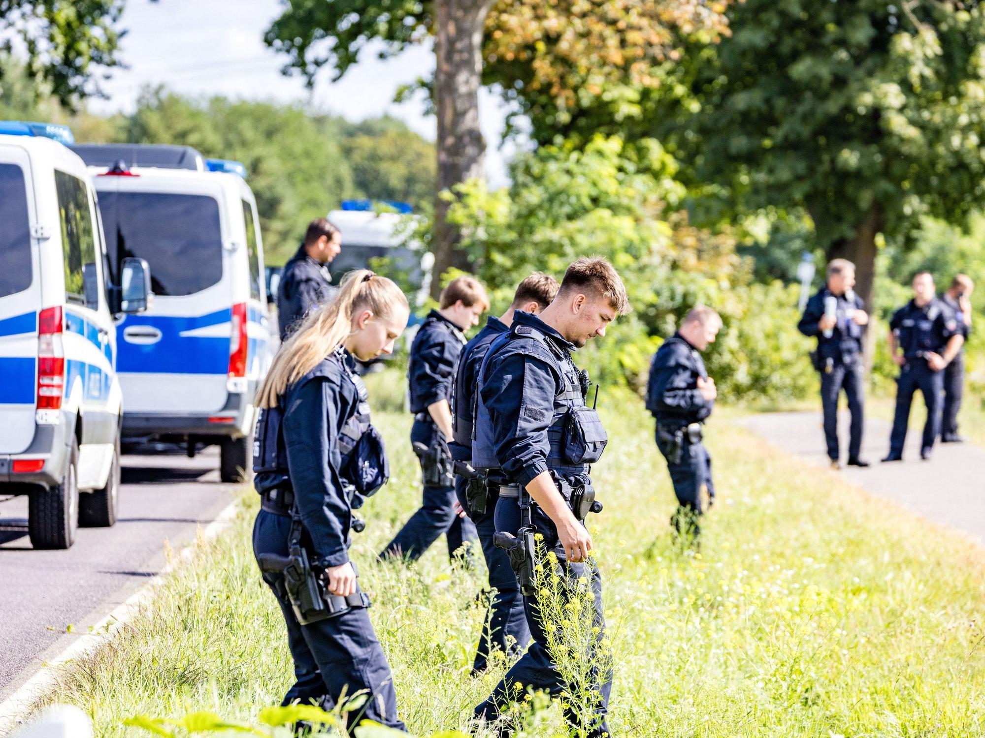 Einsatzkräfte einer Polizeihundertschaft durchsuchen großräumig die Umgebung. Nach der Sabotage am Stromnetz in Südbrandenburg sucht die Polizei vor Ort weiter nach Spuren, um die Täter zu ermitteln.