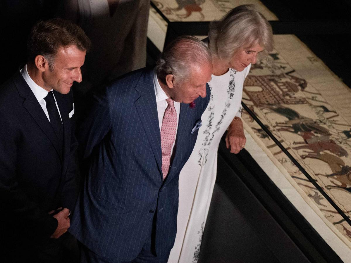 Emmanuel Macron, König Charles III. und Königin Camilla betrachten bei einer Vorbesichtigung im British Museum Teile des historischen Teppichs von Bayeux.