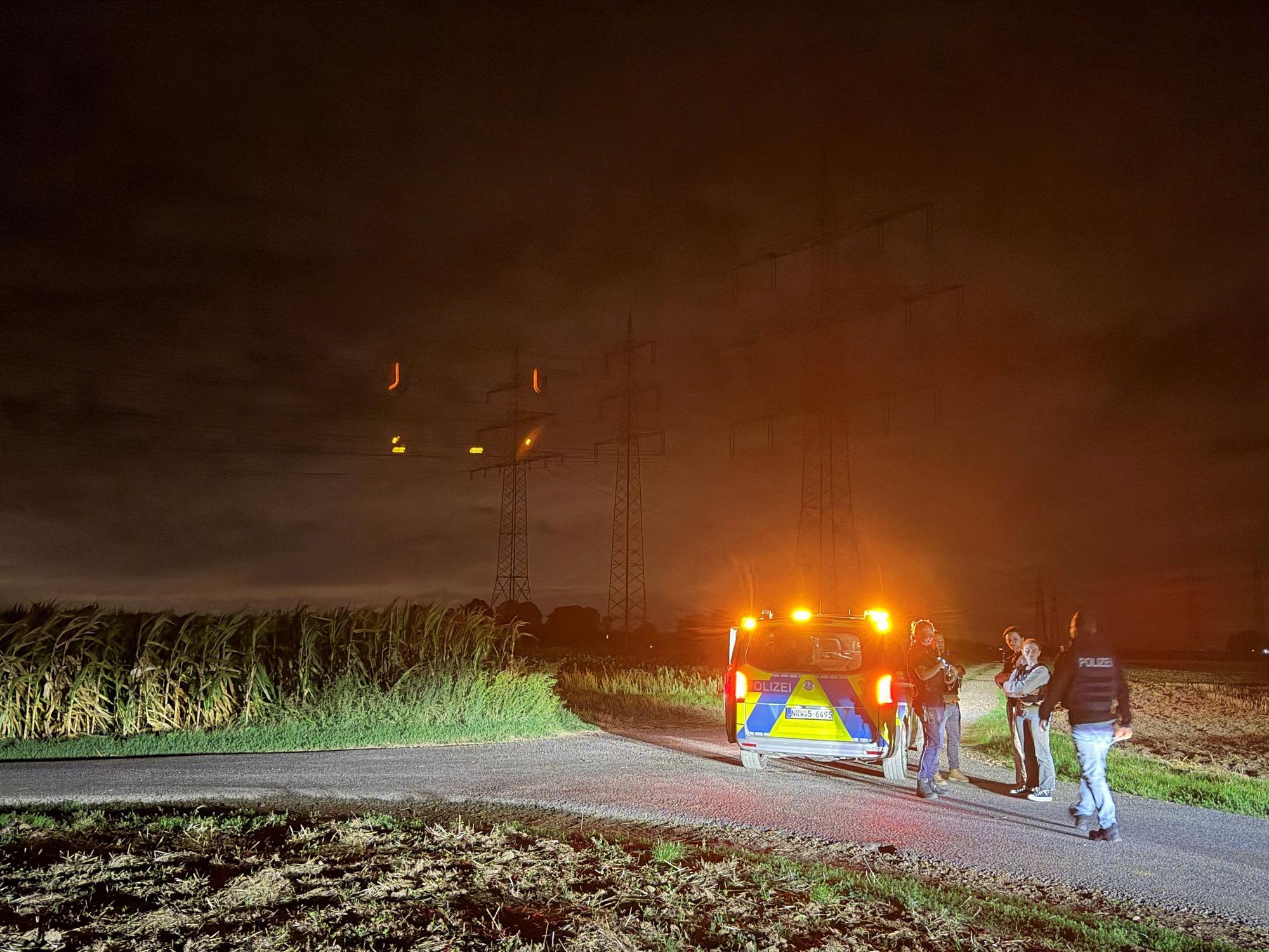 Polizisten stehen in der Nähe eines Umspannwerks.