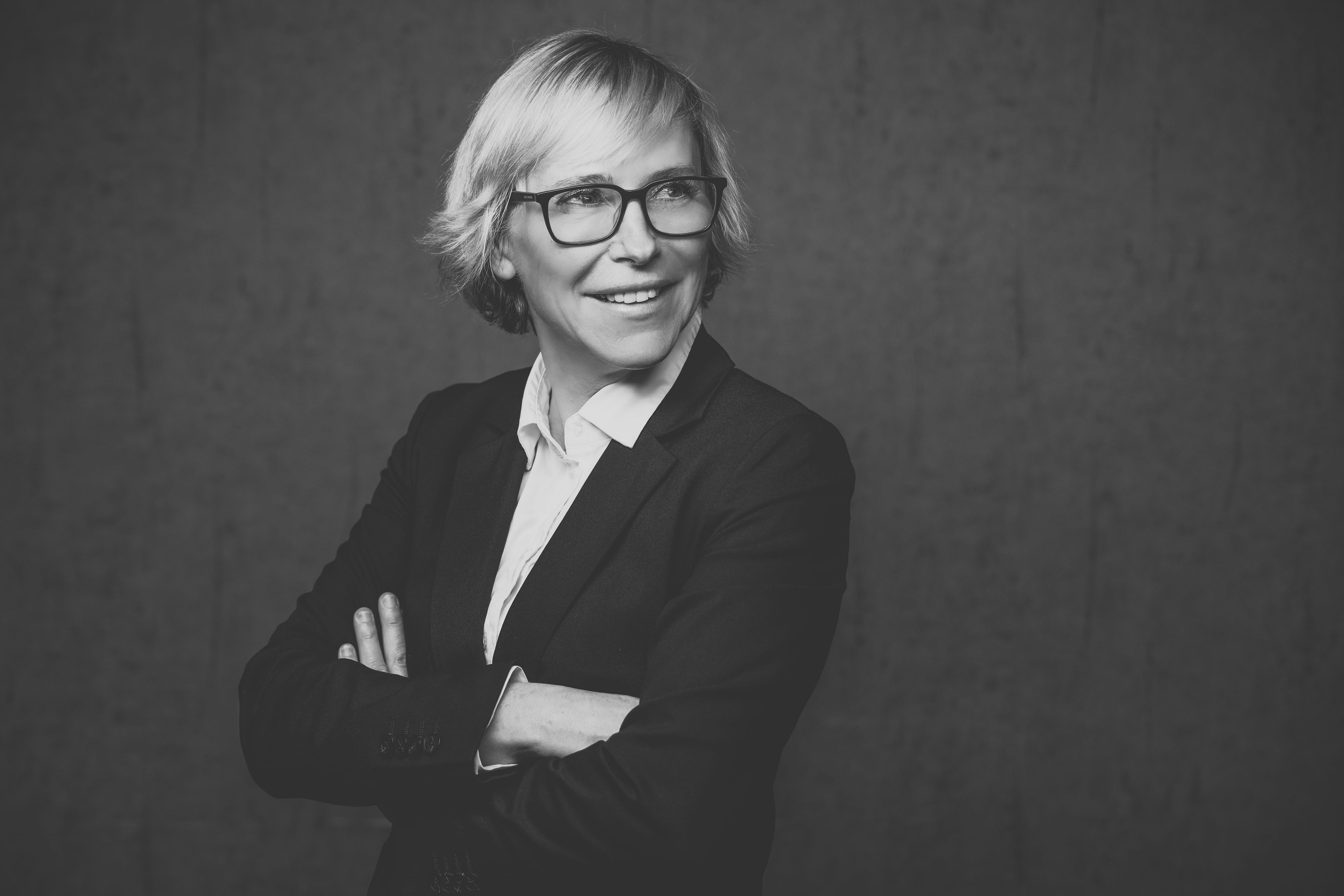 Eine Frau mit kurzen blonden Haaren und Brille
