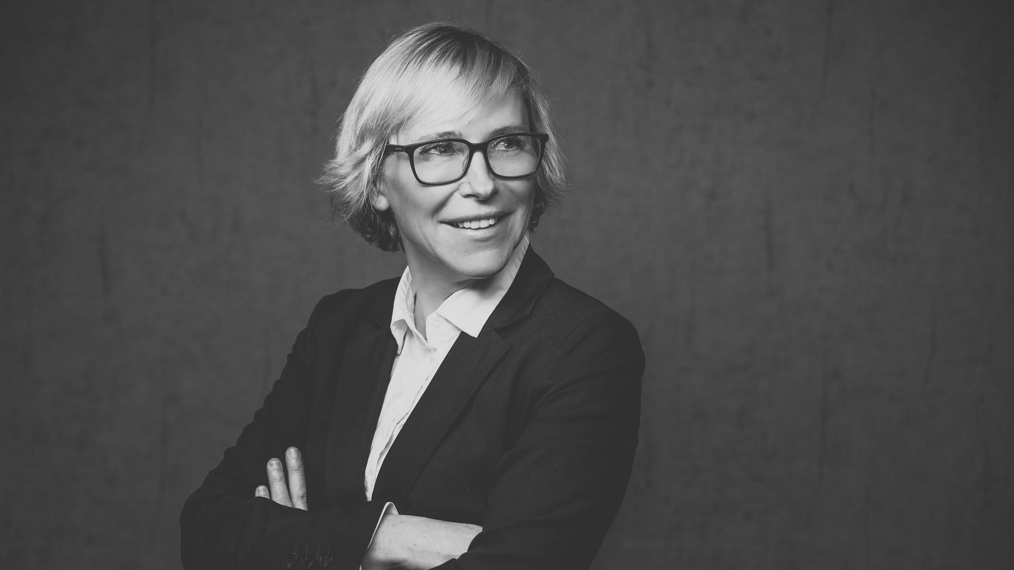Eine Frau mit kurzen blonden Haaren und Brille