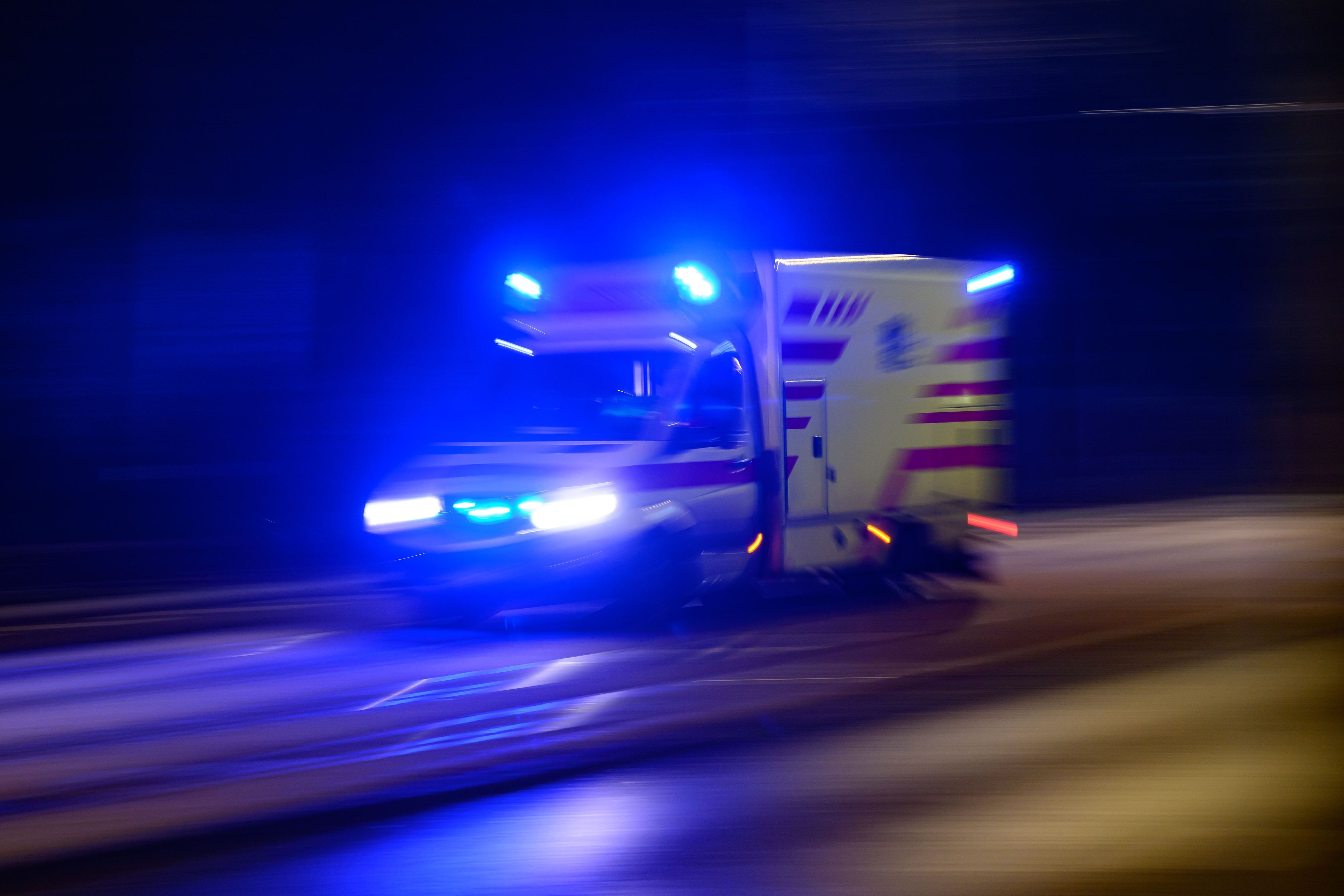 Ein Rettungswagen fährt am Abend mit Blaulicht zum Einsatz.