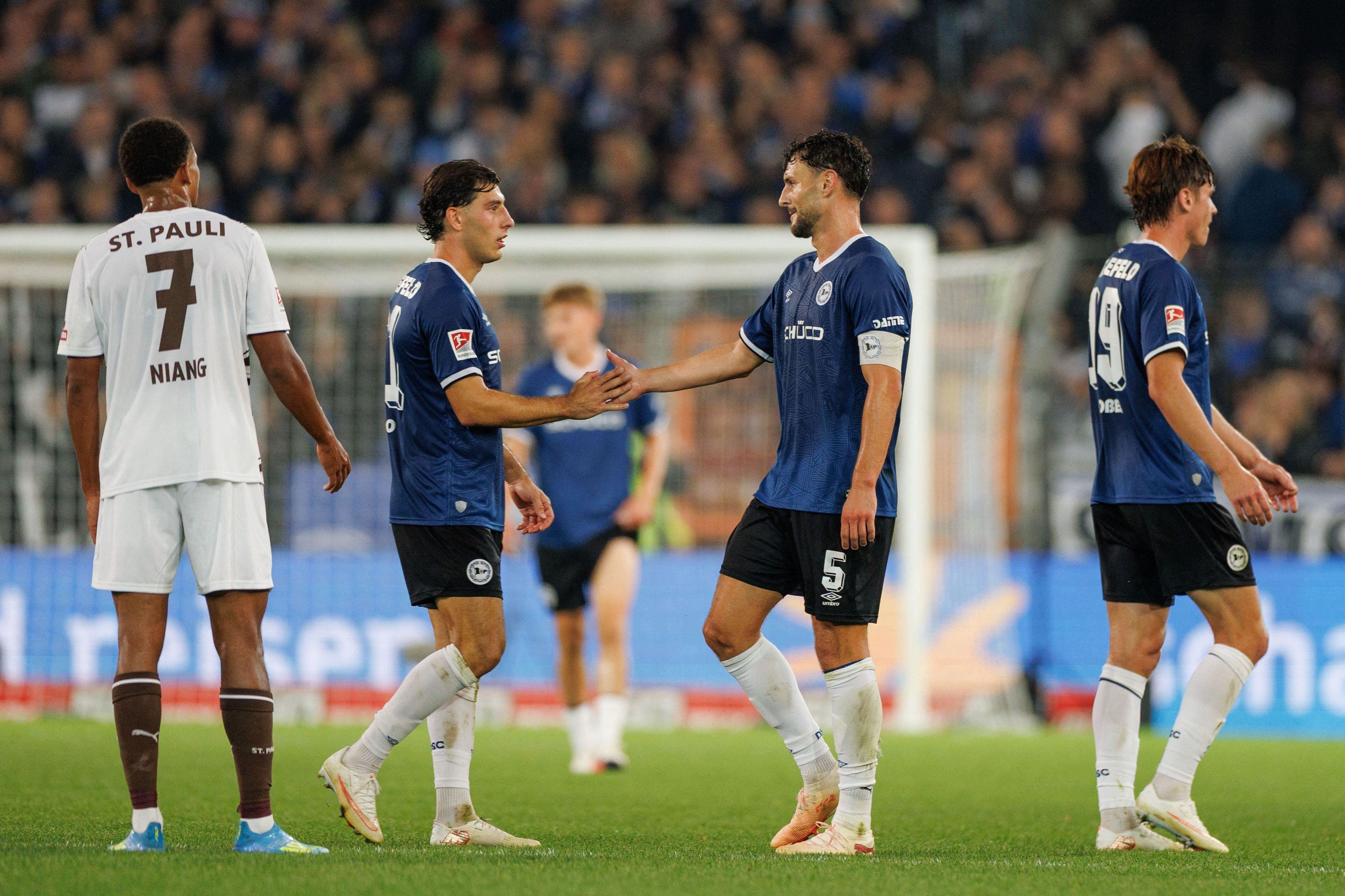 Youssoupha Niang (FC St. Pauli, l-r), Stefano Russo (Arminia Bielefeld), Maximilian Bauer (Arminia Bielefeld) und Maximilian Großer (Arminia Bielefeld) nach Ende des Spiels.