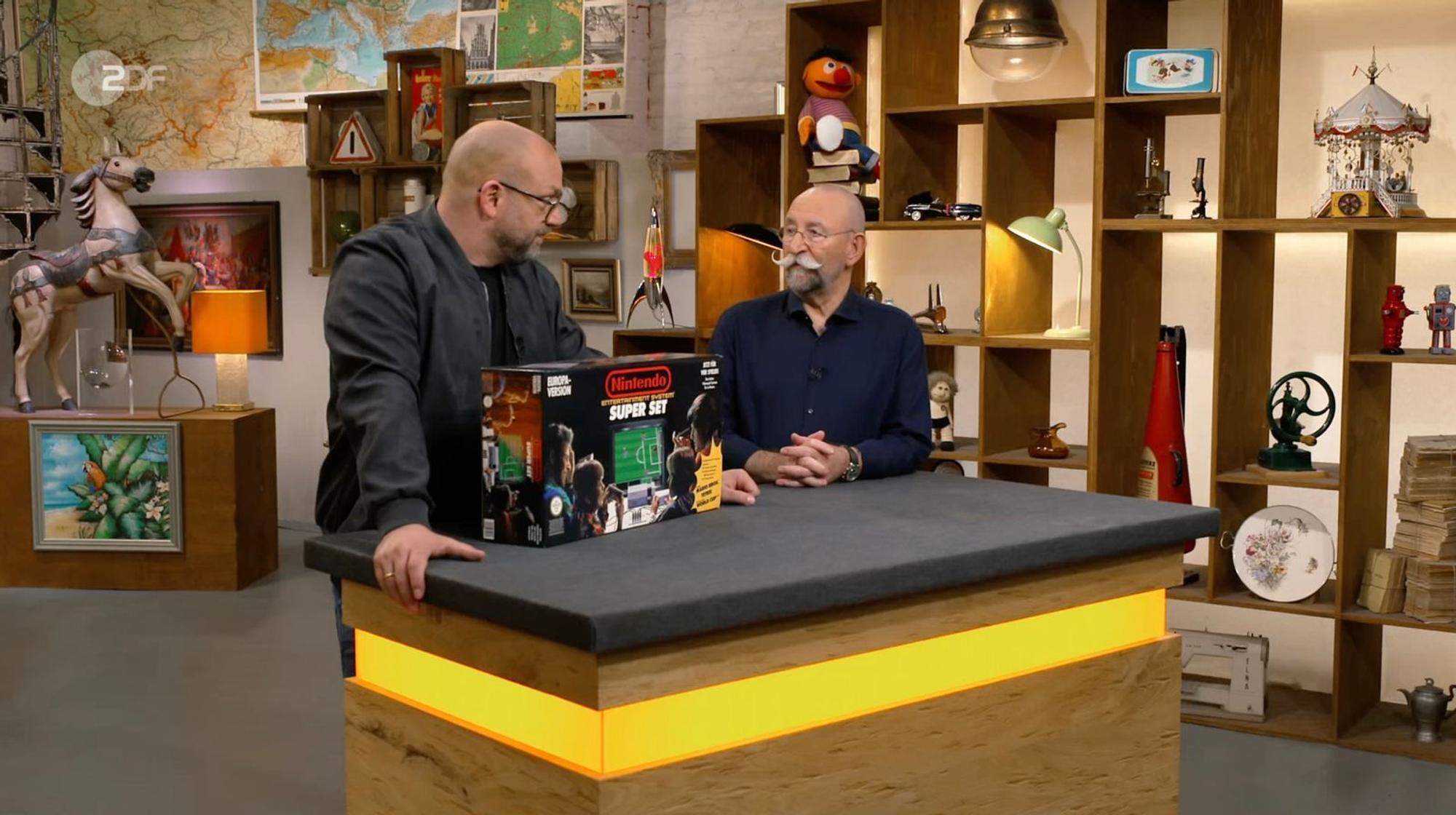 „Was ist das?“, fragte Horst Lichter (rechts) in der Freitagsausgabe der ZDF-Trödelshow „Bares für Rares“ etwas irritiert über das Nintendo Entertainment System in OVP. (Bild: ZDF)