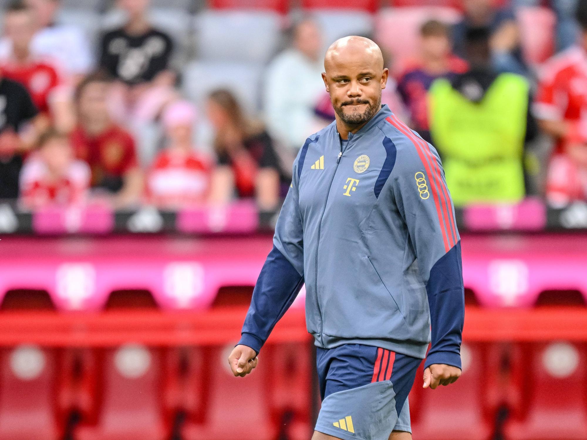 Vincent Kompany in Trainingsjacke mit Sponsorenlogos.