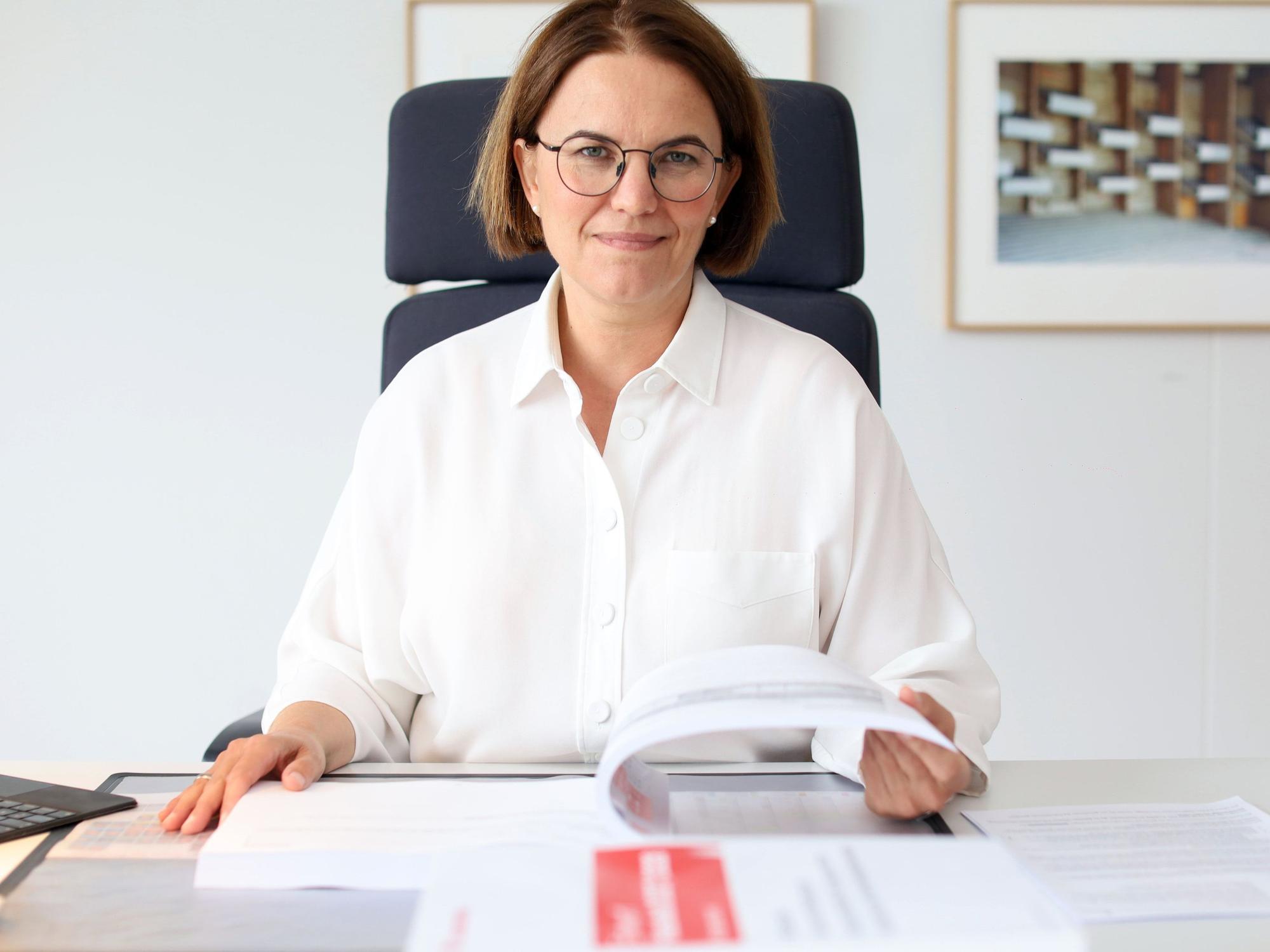 Stadtkämmerin Dörte Diemert in ihrem Büro mit dem ausgedruckten Entwurf für den Kölner Haushalt 2027/2028.
