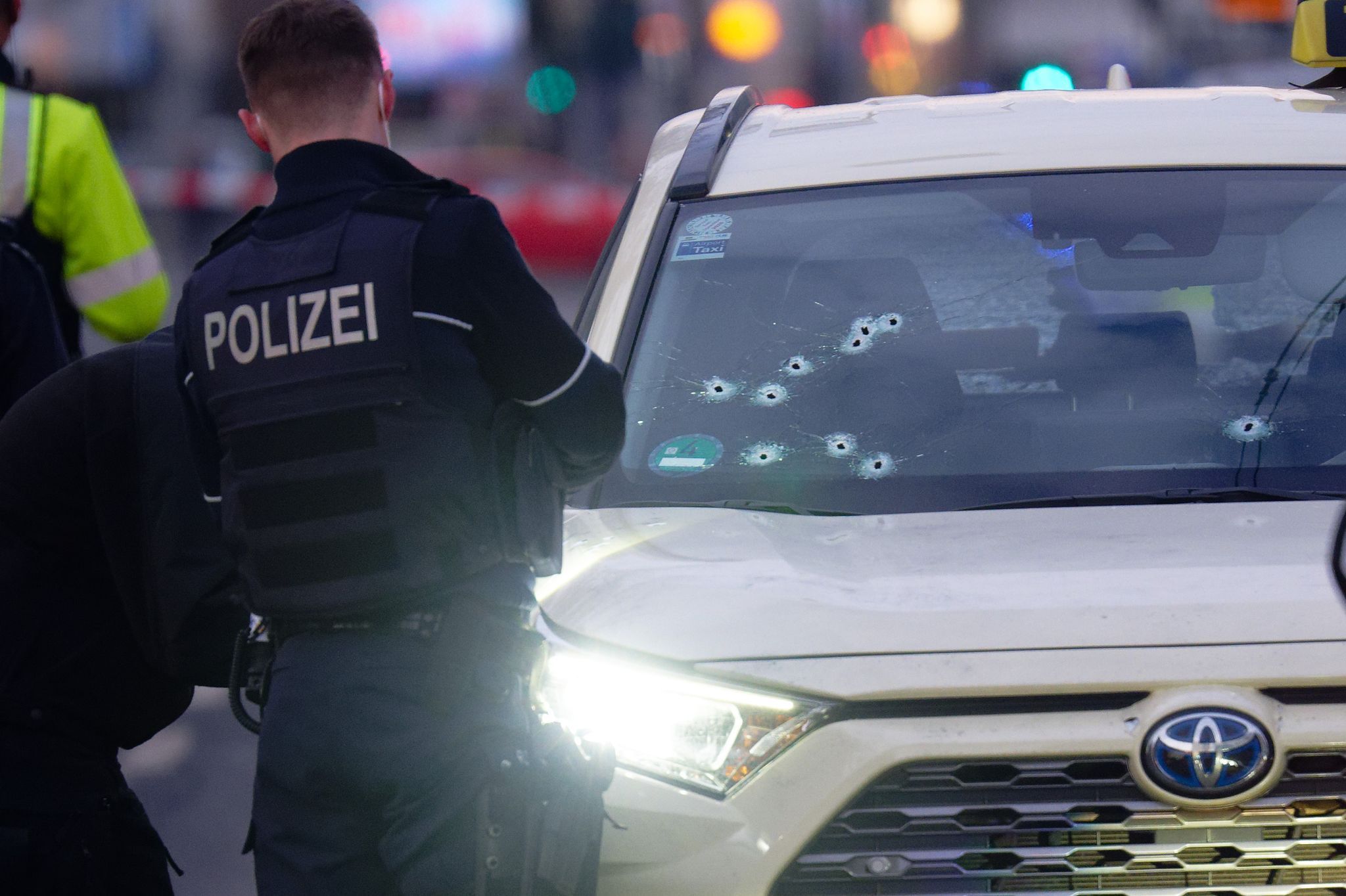 In der Frontscheibe eines Taxis sind mehrere Einschusslöcher.