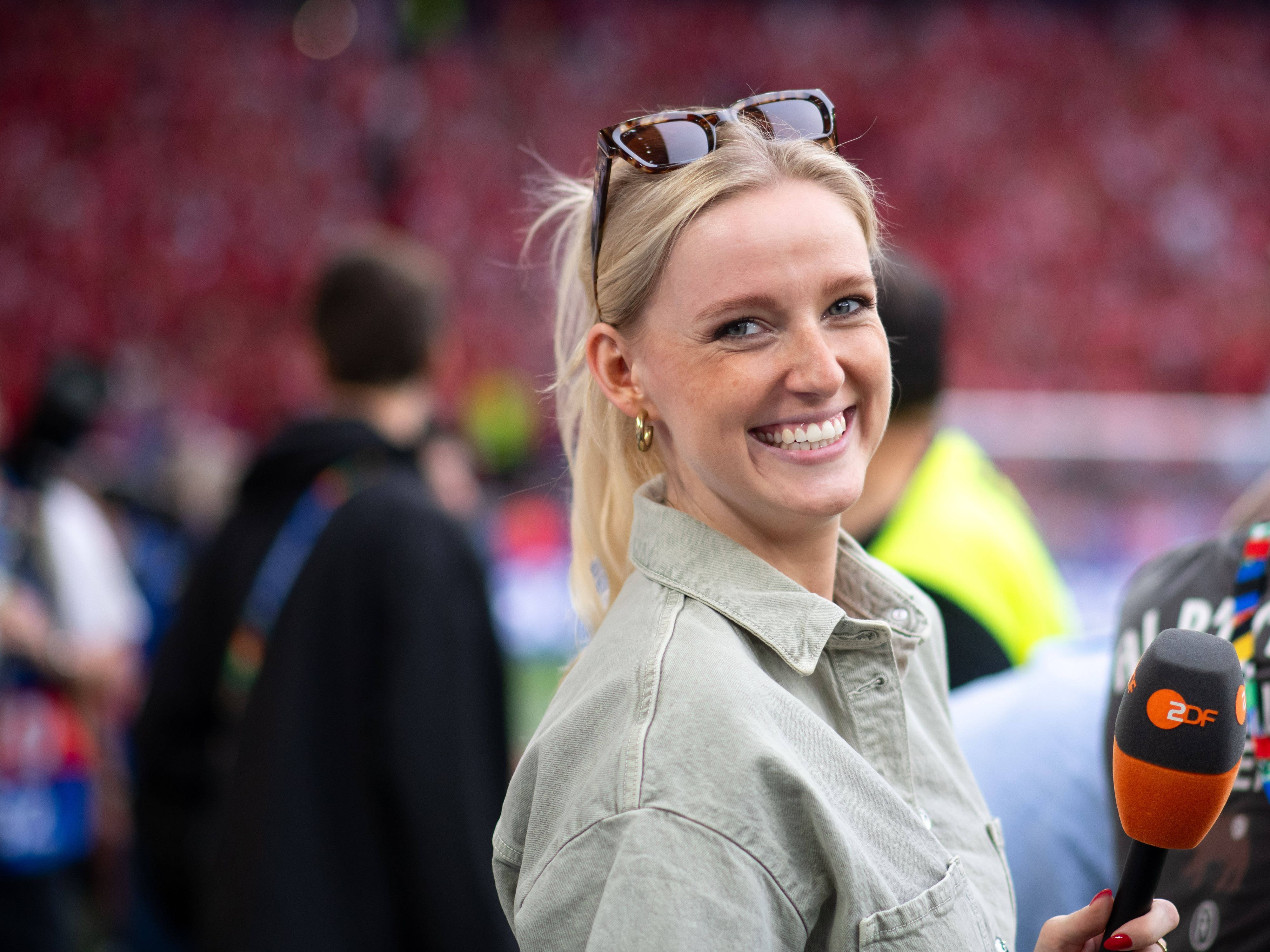Franziska Müllers lächelt und hält ein Mikrofon