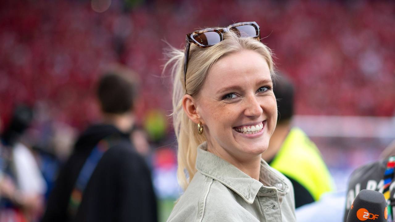 Franziska Müllers lächelt und hält ein Mikrofon