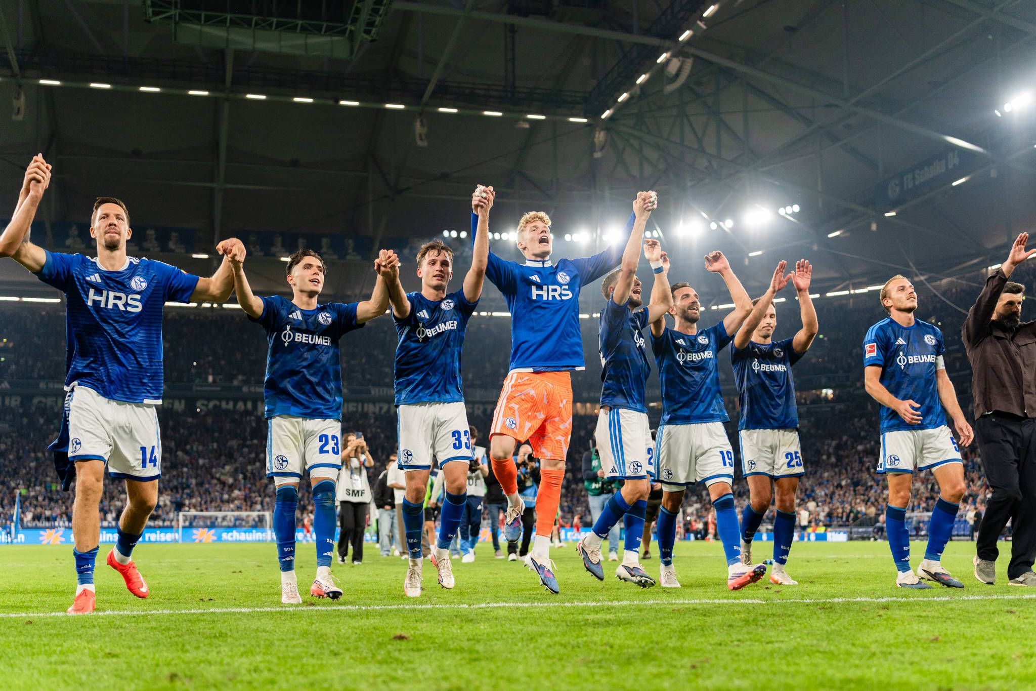 Schalker Spieler jubeln mit Fans.