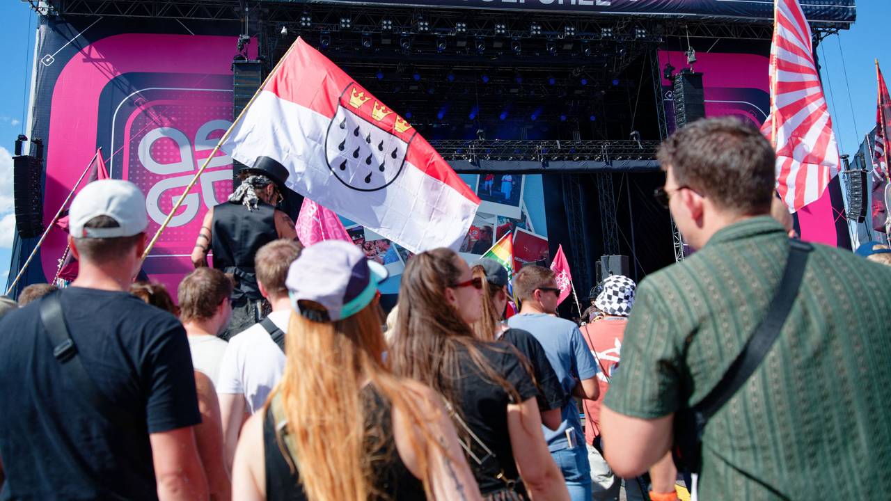 04.09.2026, Baden-Württemberg, Hockenheim: Besucher stehen vor einer Bühne beim Glücksgefühle-Festival auf dem Hockenheimring und halten eine Kölner Stadtflagge. Foto: Uwe Anspach/dpa +++ dpa-Bildfunk +++