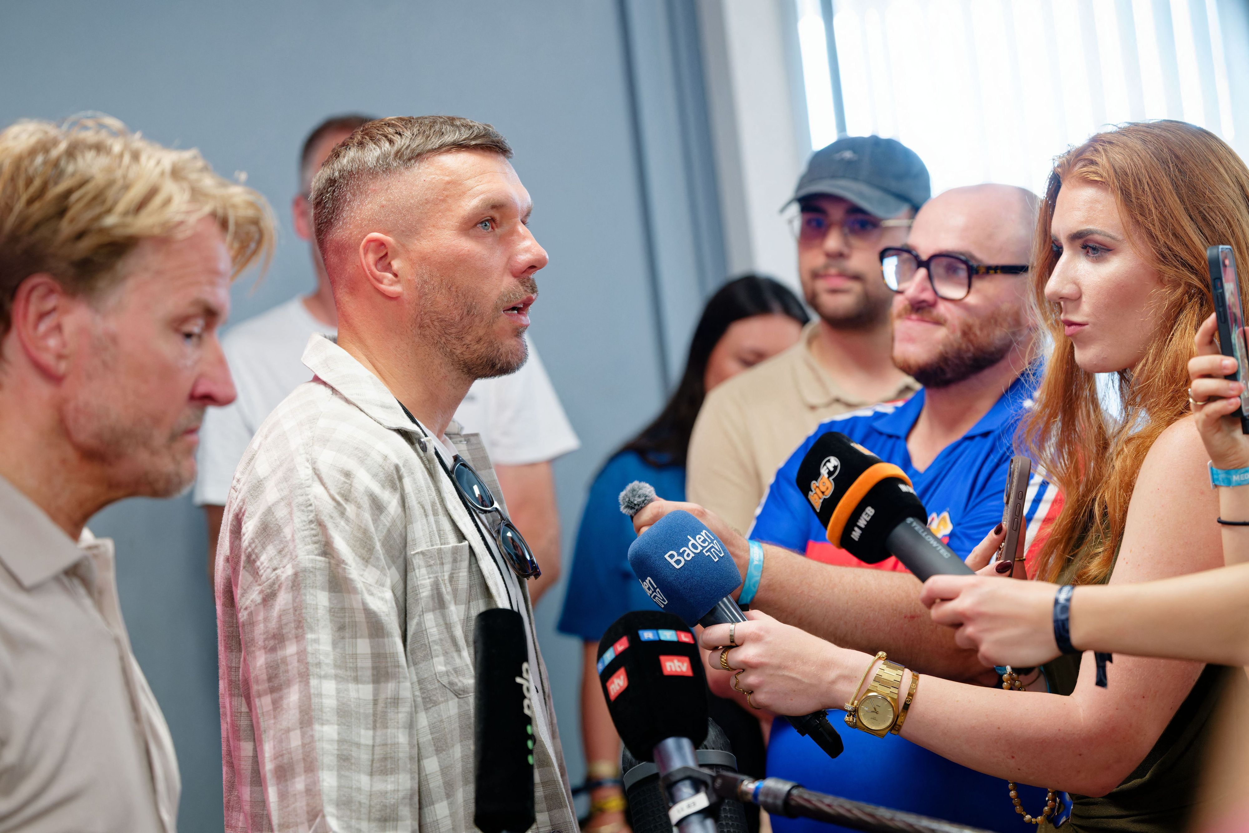Markus Krampe (l), Organisator des Festivals, und Lukas Podolski beantworten Fragen bei einer Pressekonferenz beim Glücksgefühle-Festival auf dem Hockenheimring.
