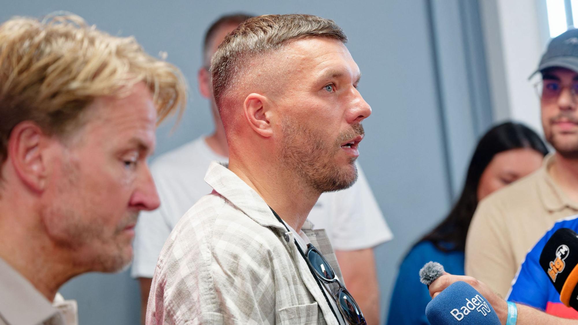 Markus Krampe (l), Organisator des Festivals, und Lukas Podolski beantworten Fragen bei einer Pressekonferenz beim Glücksgefühle-Festival auf dem Hockenheimring.