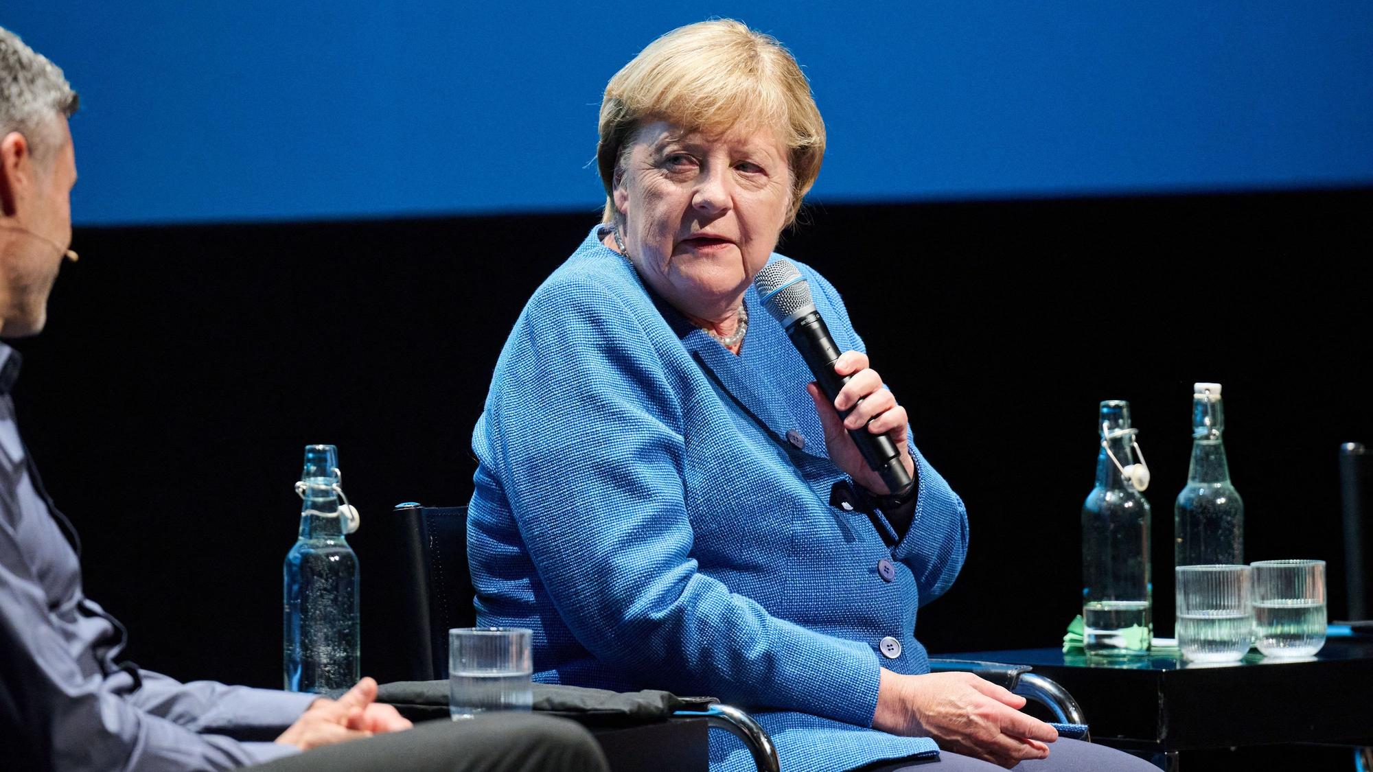 Angela Merkel sitzt bei einer Talkrunde auf der Bühne.