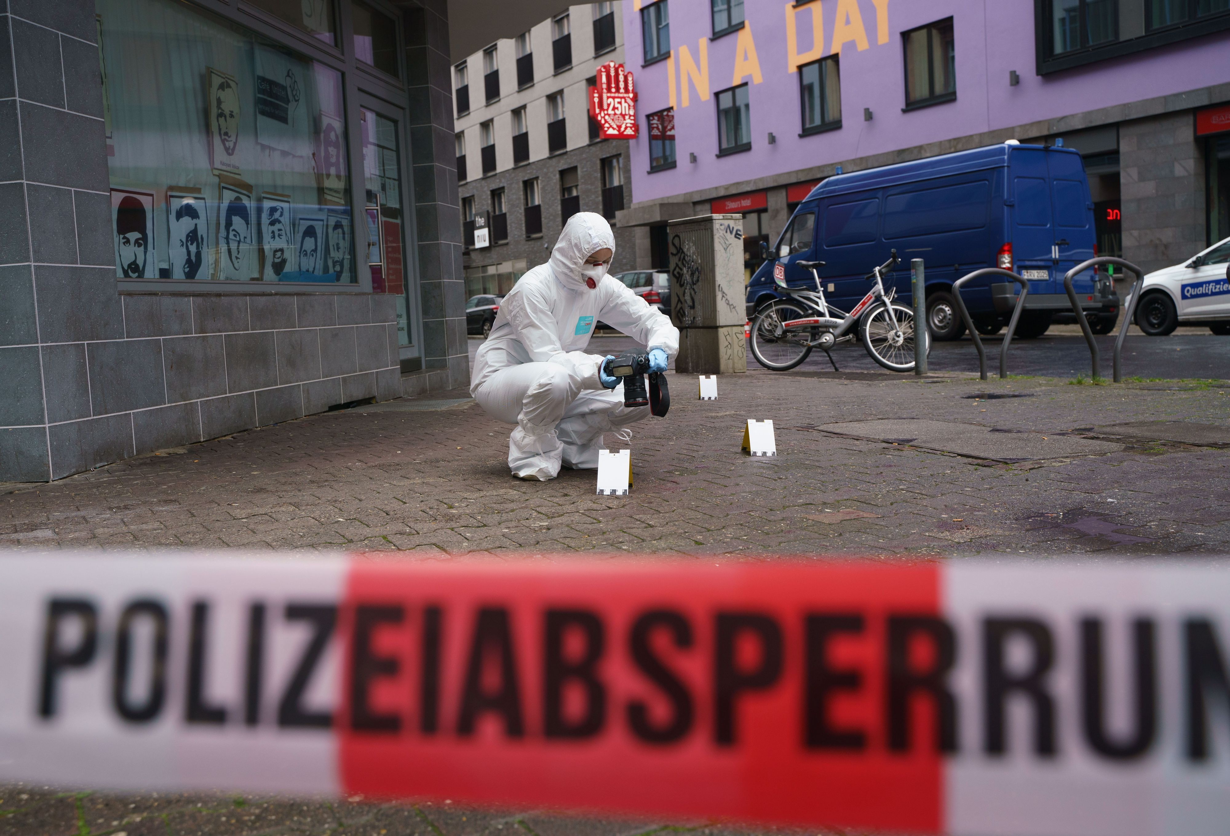 Ein Beamter der Spurensicherung sichert Blutspuren auf dem Gehweg, der mit Polizeiflatterband abgesperrt ist.