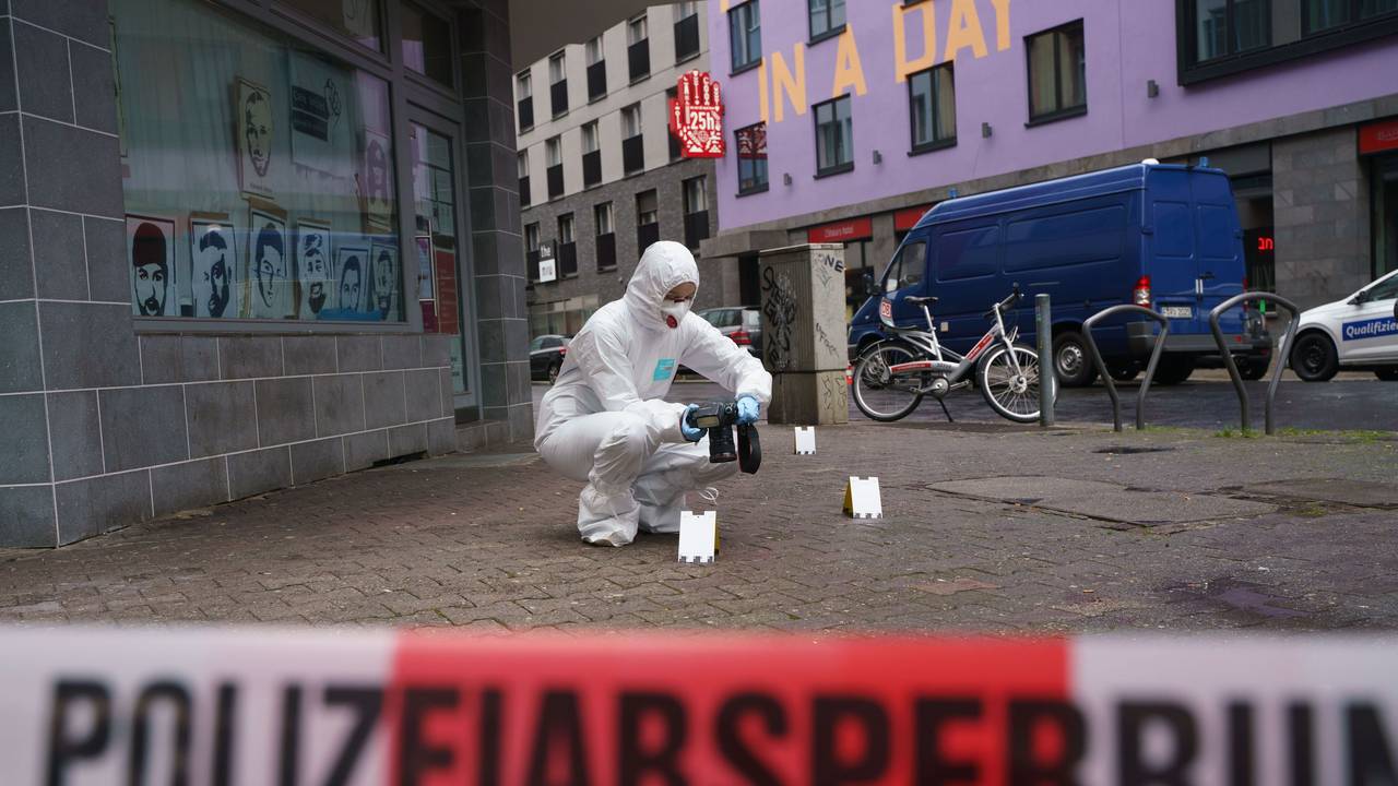 Ein Beamter der Spurensicherung sichert Blutspuren auf dem Gehweg, der mit Polizeiflatterband abgesperrt ist.