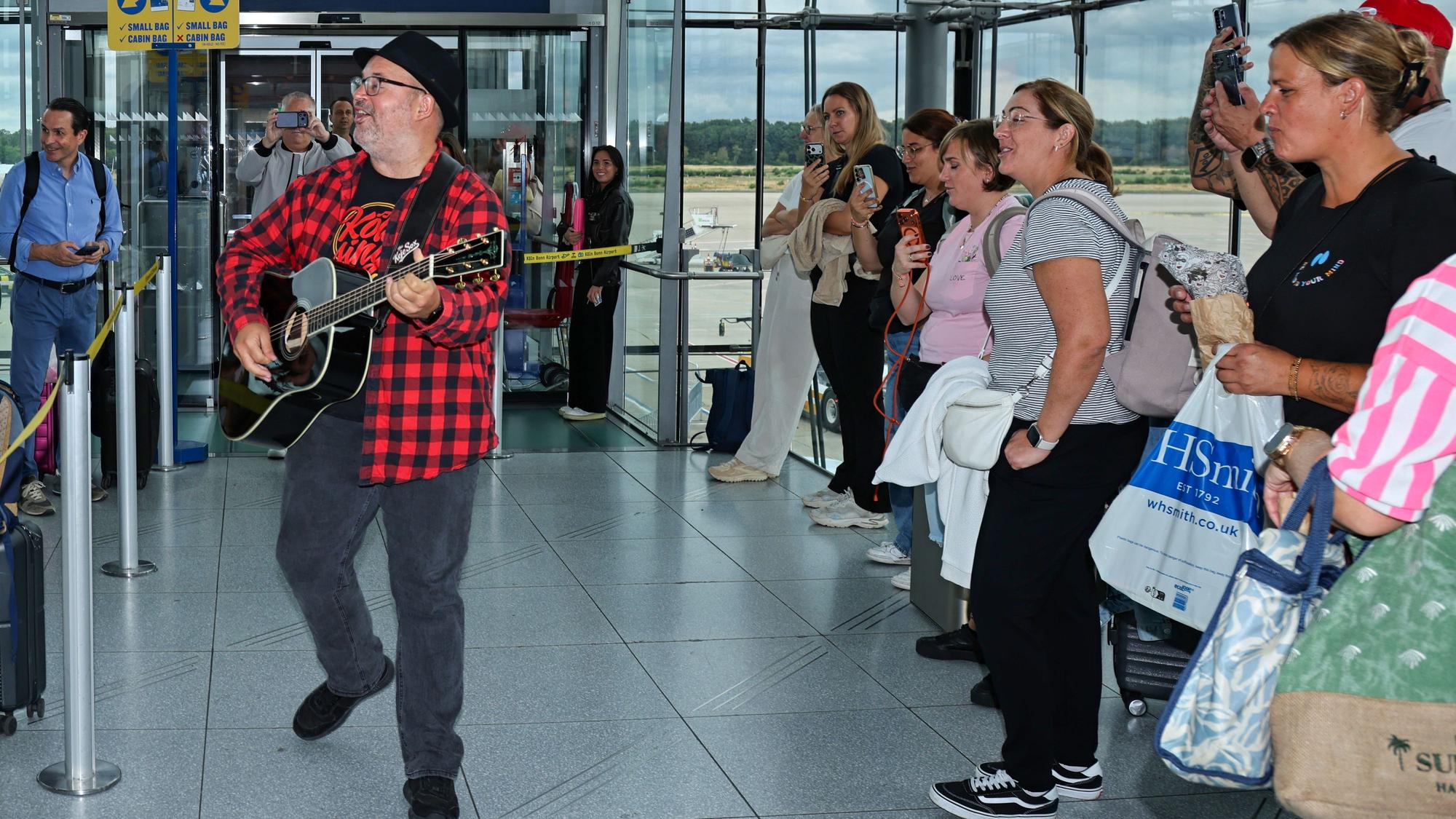 Björn Heuser singt am Flughafen-Gate für die Passagiere.