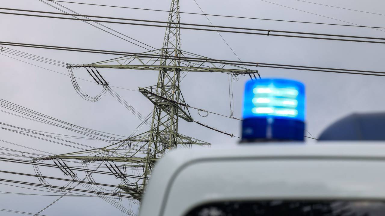 An einem Umspannwerk steht ein Polizeifahrzeug, von dem man aber nur das Blaulicht sieht.