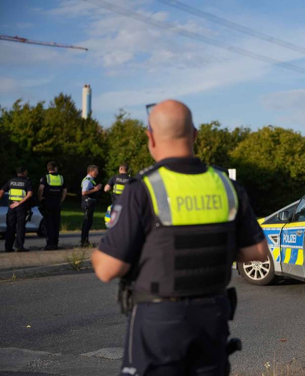 Weisweiler: Polizisten sind am Montag (7. September 2026) nahe dem Kraftwerk (hinten) im Einsatz. Nach einer Serie von Sabotage-Aktionen hat die Polizei ihre Ermittlungen und Fahndung ausgeweitet.