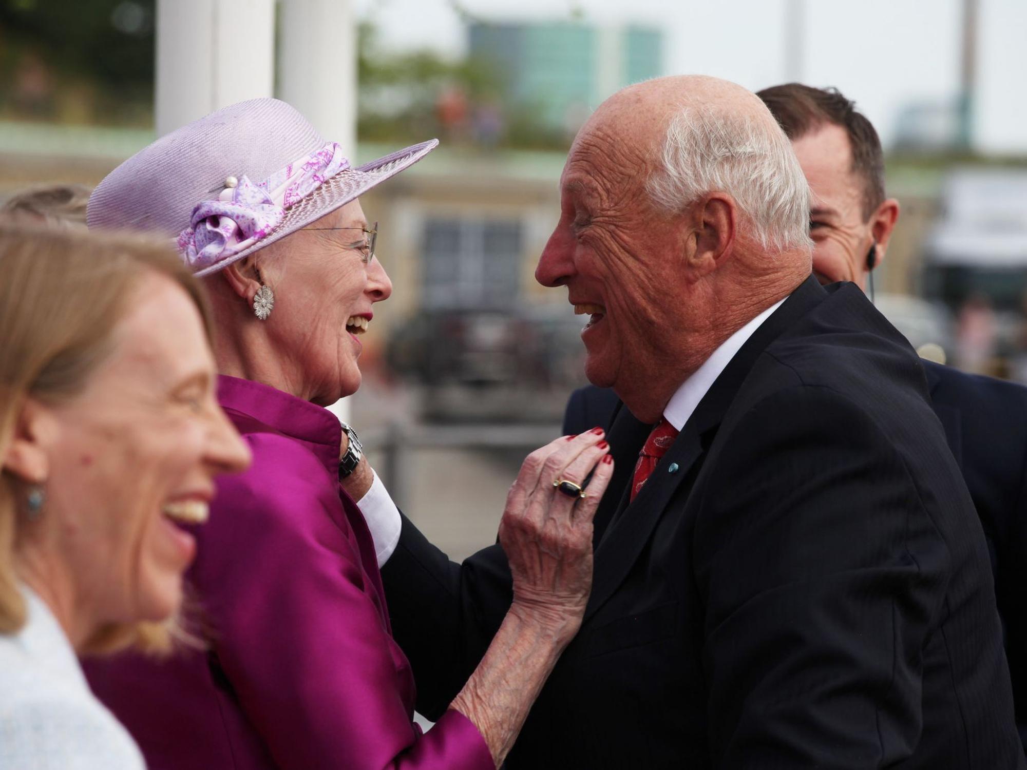 Königin Margrethe und König Harald V. lachen miteinander.
