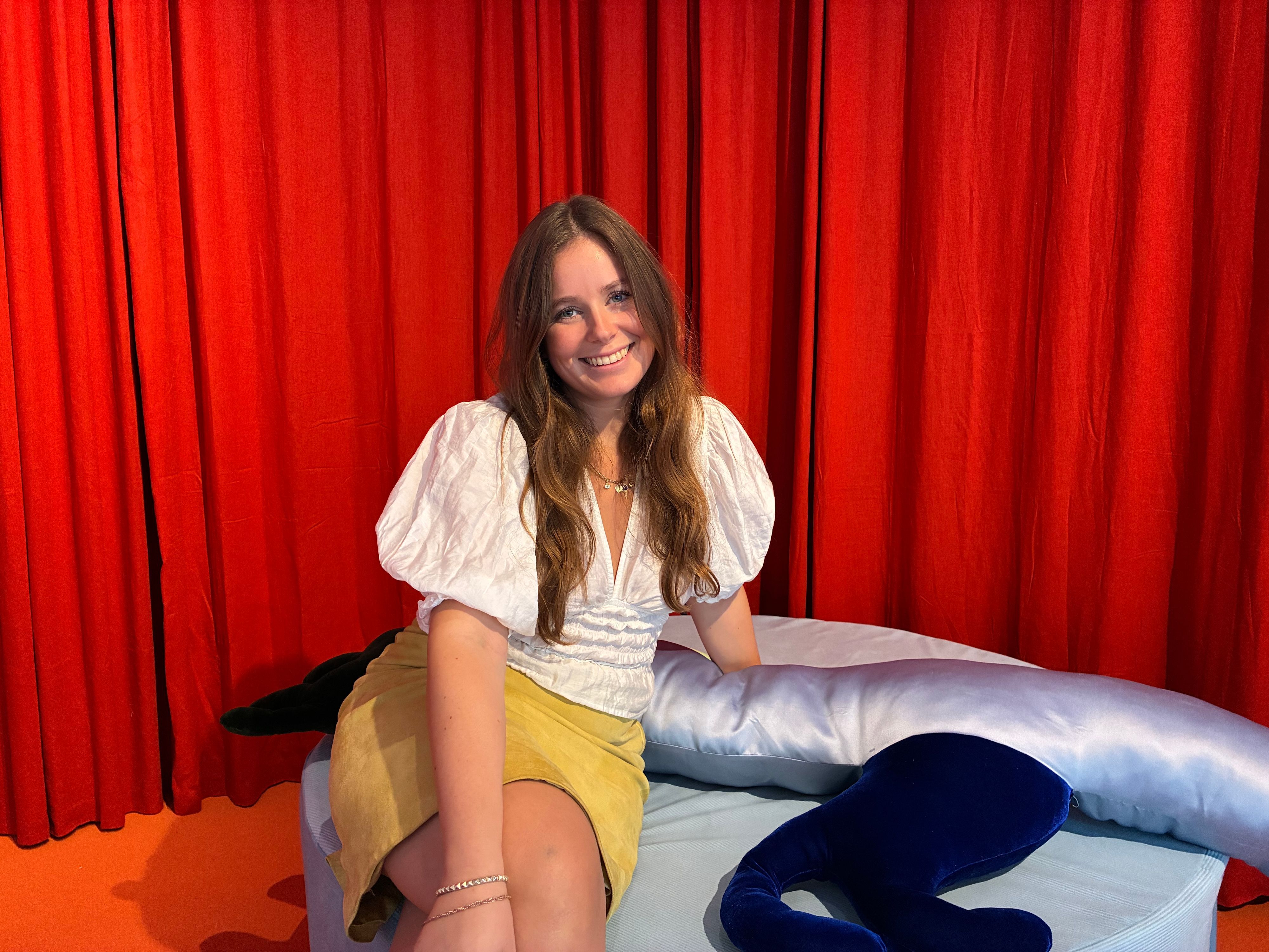Eine junge Frau sitzt auf einer Couch.