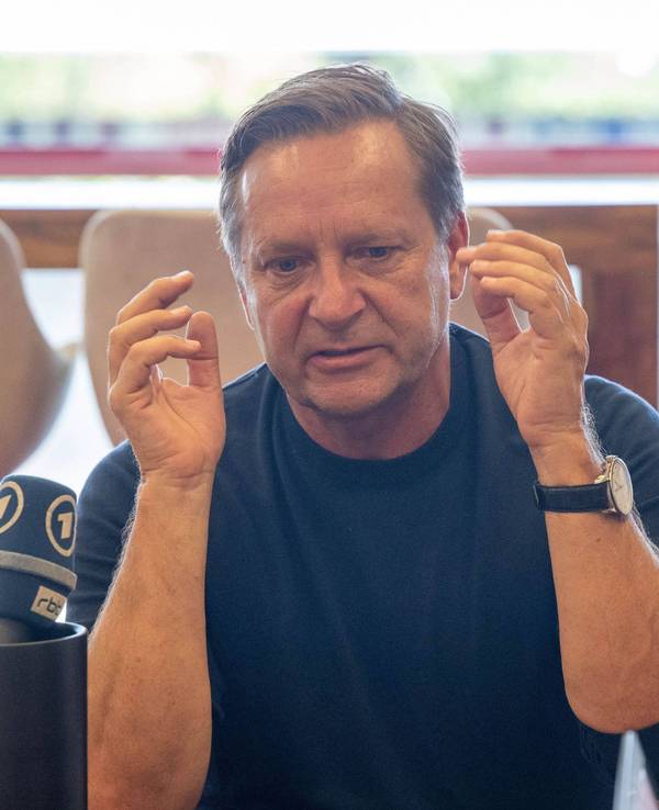 Horst Heldt gestikuliert bei einer Medienrunde.