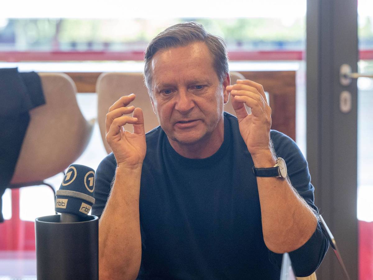 Horst Heldt gestikuliert bei einer Medienrunde.
