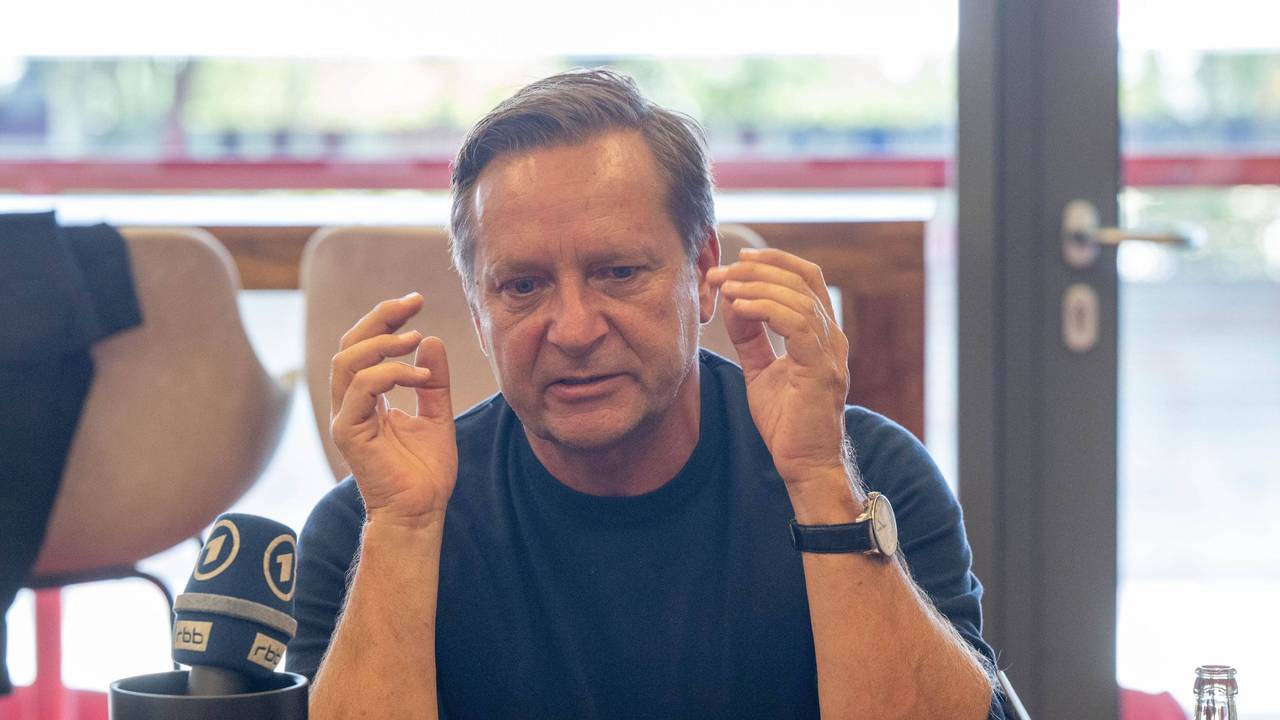 Horst Heldt gestikuliert bei einer Medienrunde.