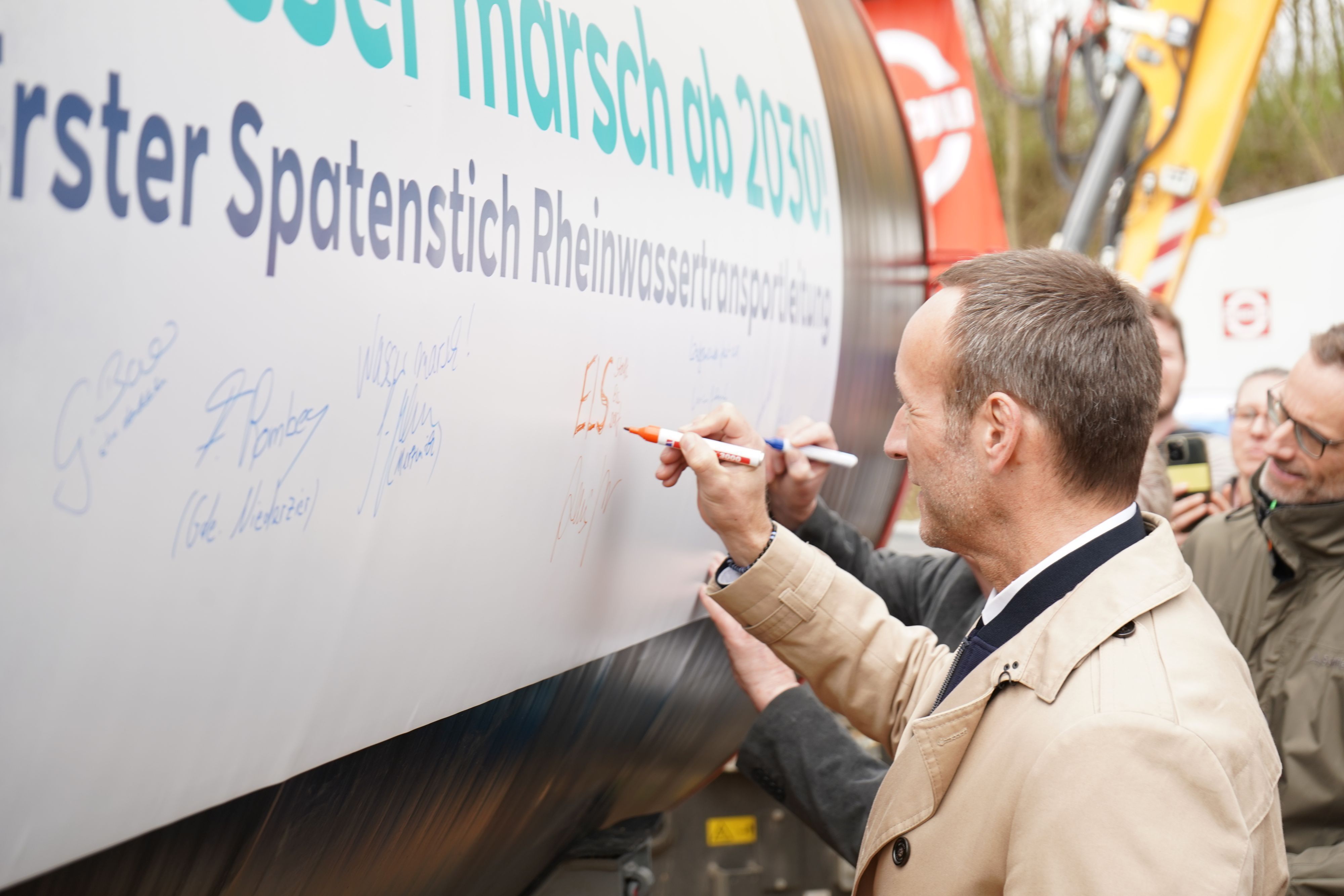 Elsdorfer Bürgermeister Andreas Heller beim Signieren eines der Rohre.