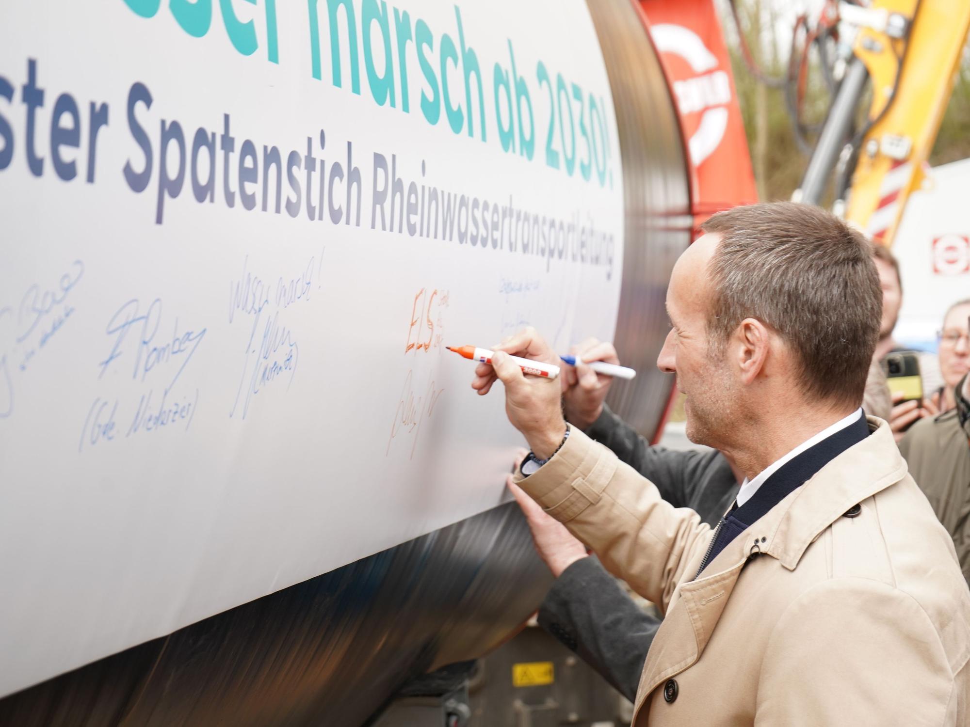 Elsdorfer Bürgermeister Andreas Heller beim Signieren eines der Rohre.