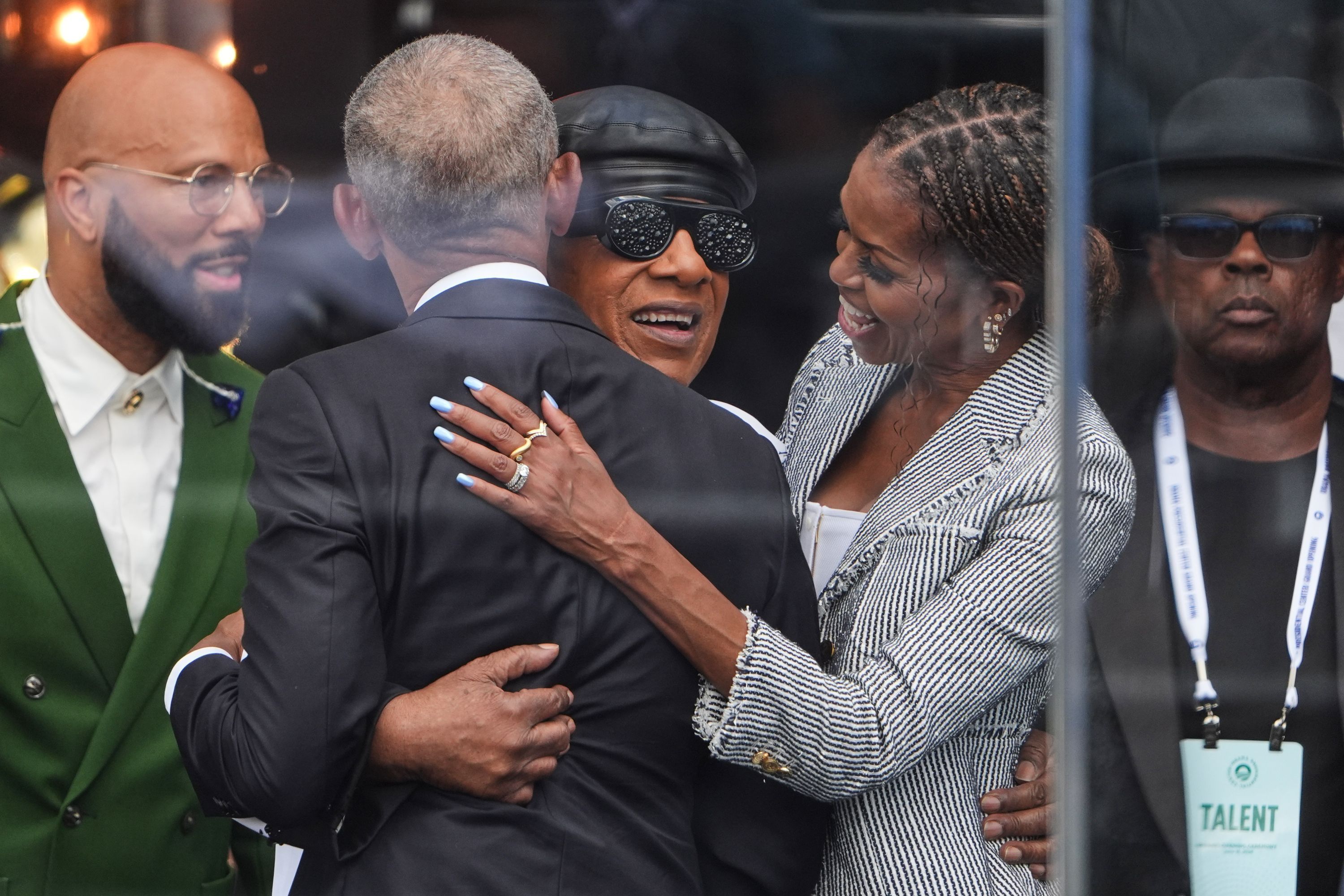 Barack Obama und Michelle Obama umarmen Stevie Wonder.