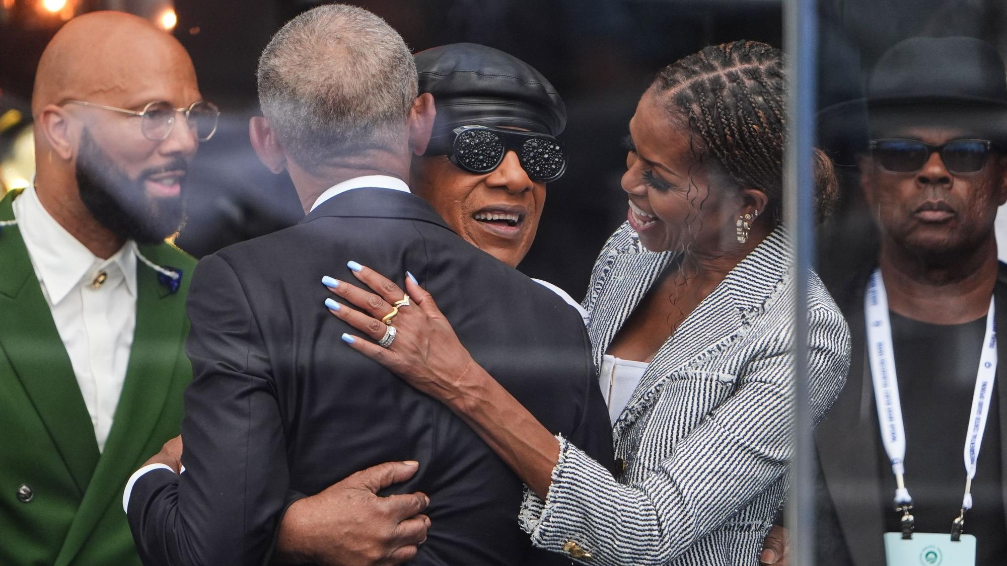 Barack Obama und Michelle Obama umarmen Stevie Wonder.