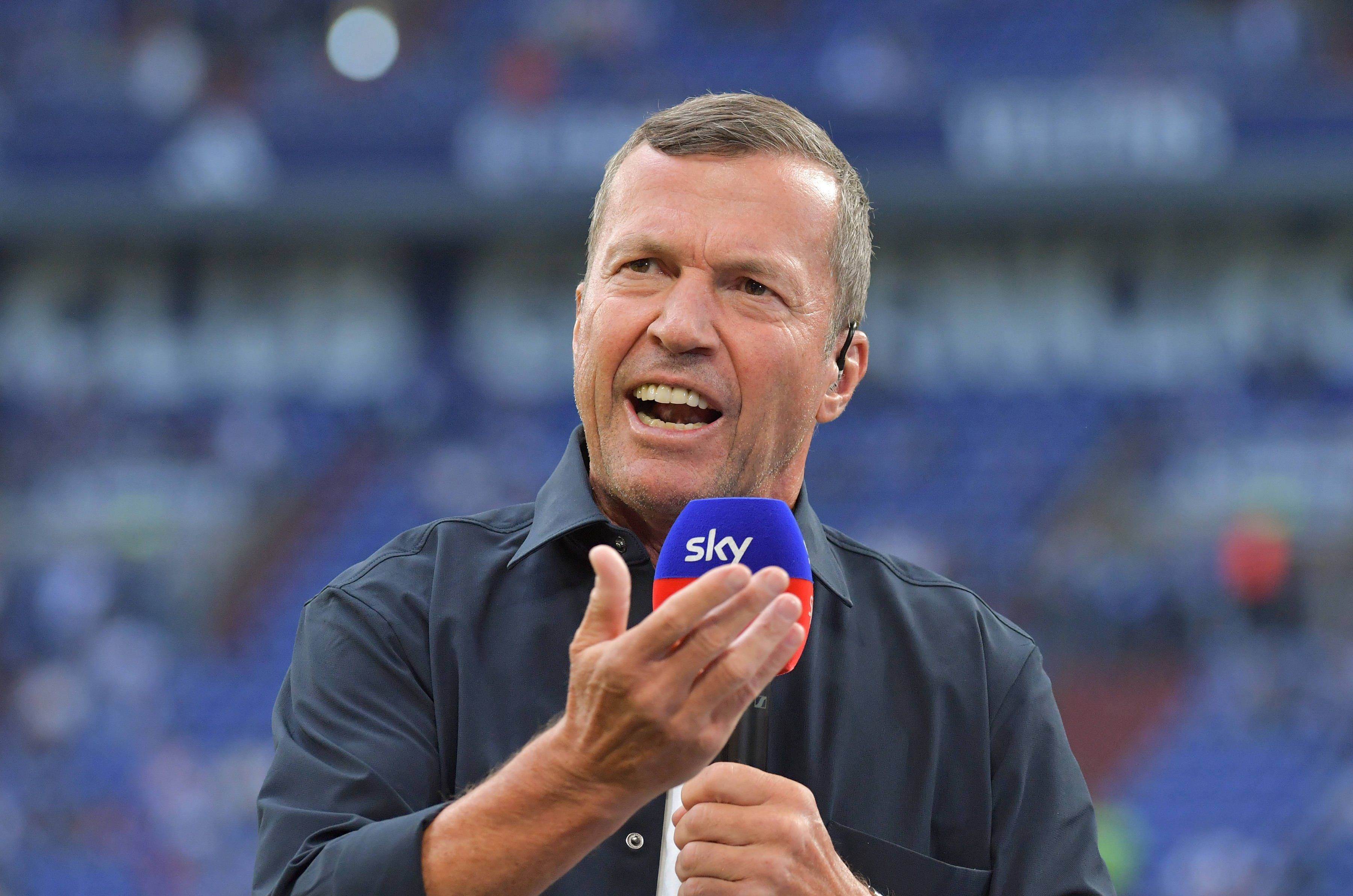 Lothar Matthäus gestikuliert mit Sky-Mikro in der Hand.