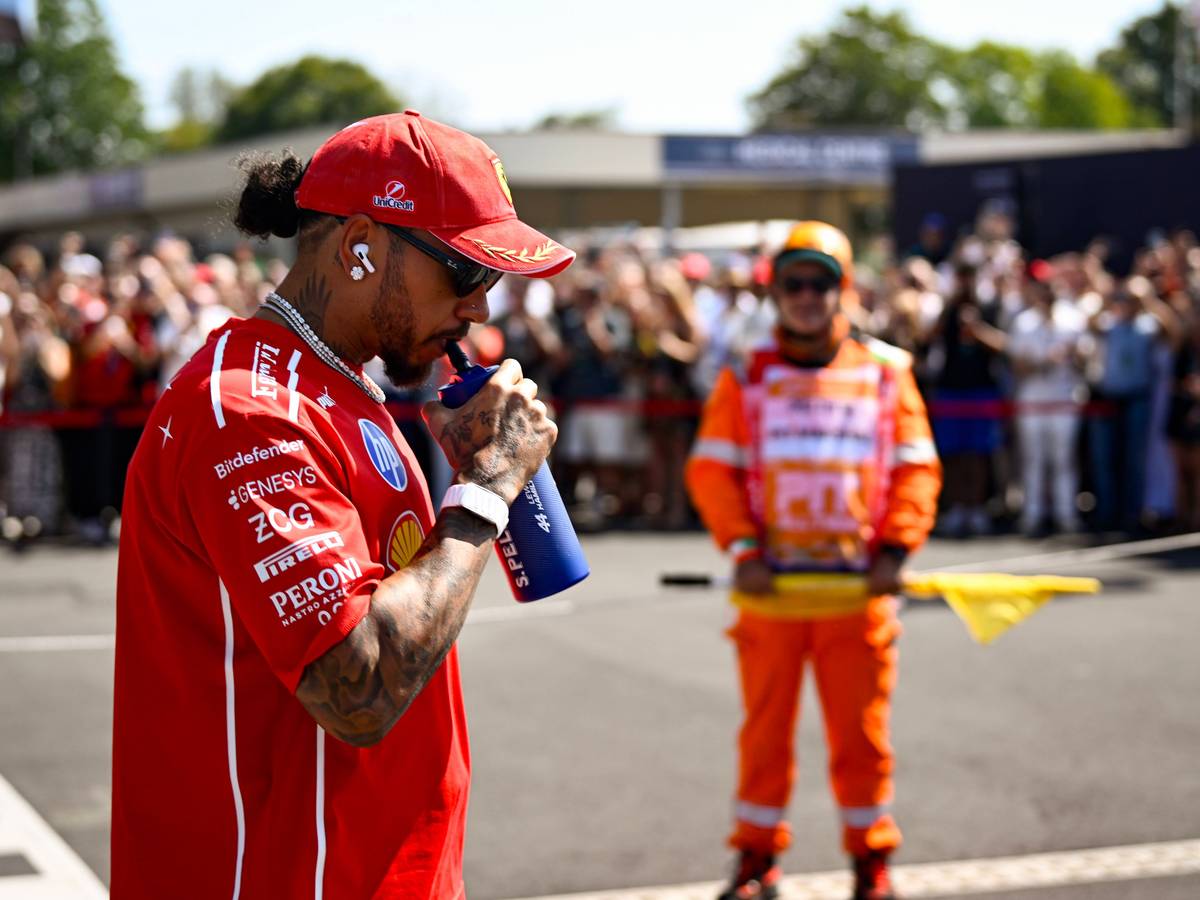 Lewis Hamilton trinkt an einer Flasche.