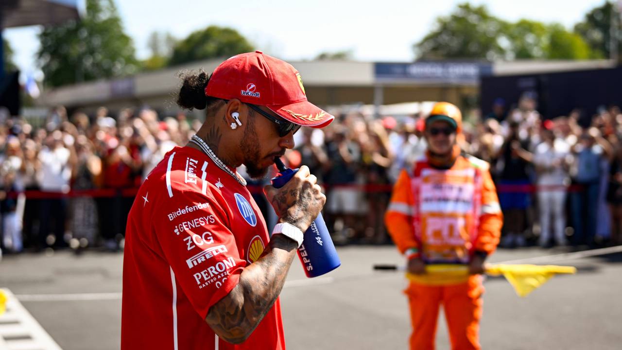 Lewis Hamilton trinkt an einer Flasche.