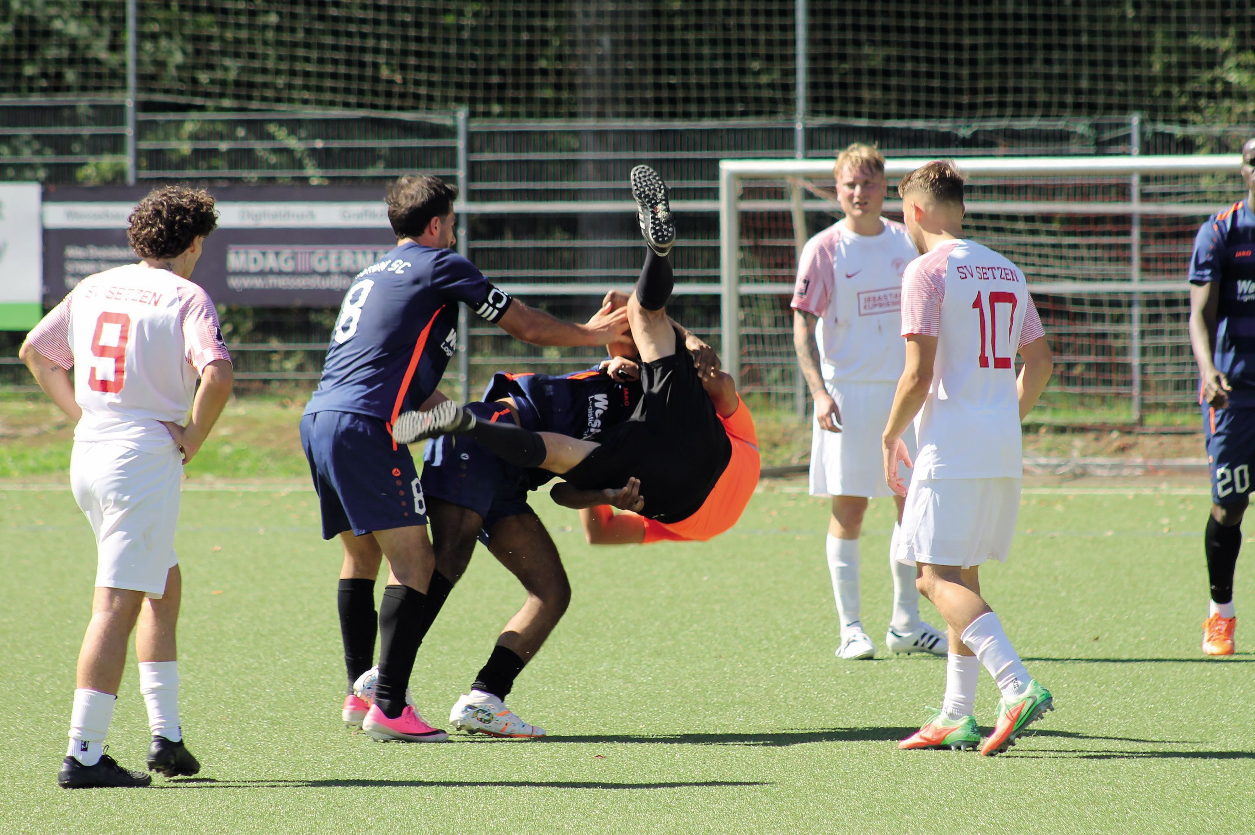 Ein Spieler wirft einen Schiedsrichter per Schulterwurf zu Boden.